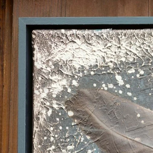 Ein gepresster Blätter in einem Bilderrahmen, der durch frostige Temperaturen brandig und mit Eiskristallen bedeckt ist.