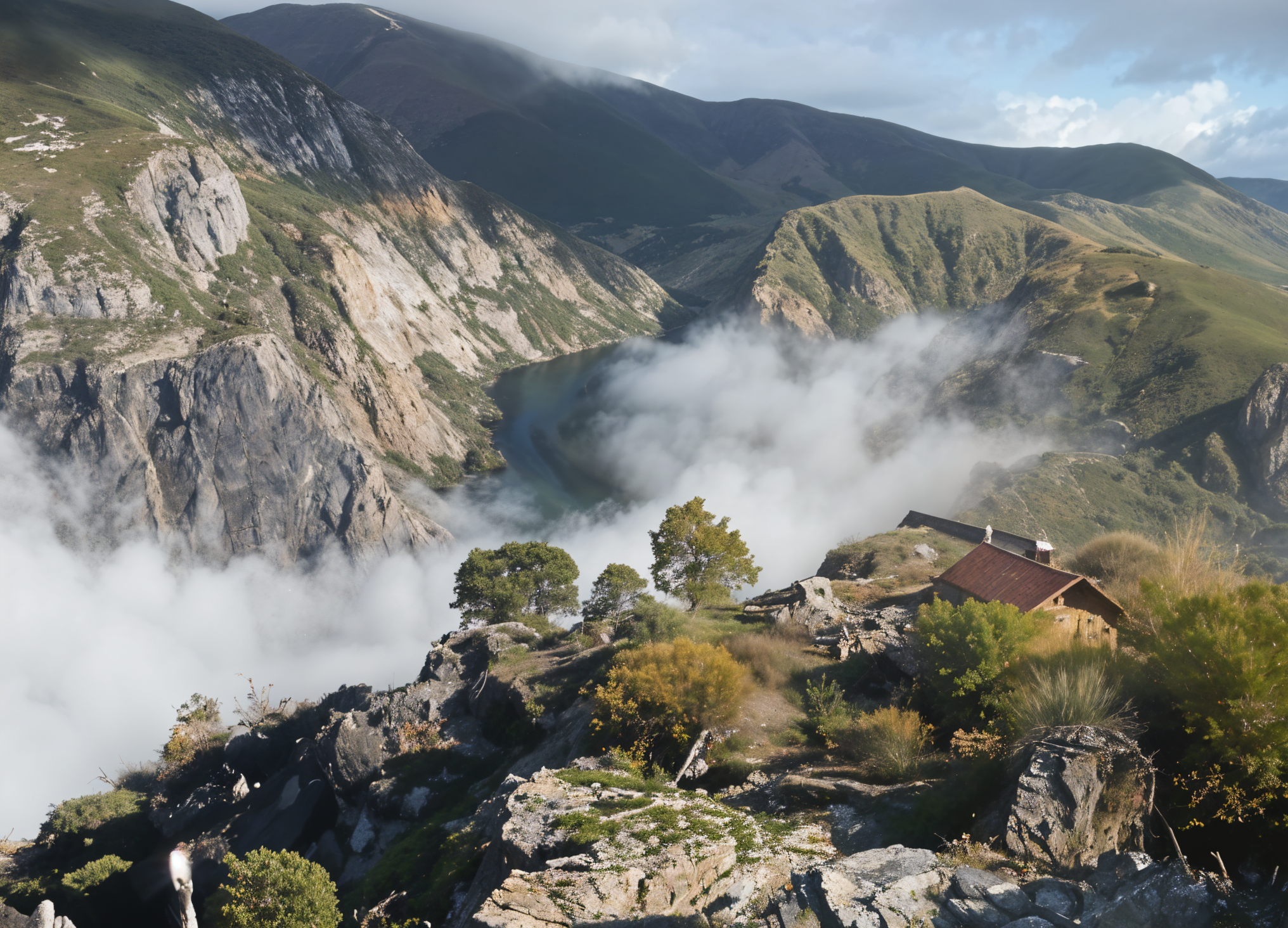 Montañas verdes con bruma y nubes en el cielo, con una pequeña casa de techo rojo en primer plano.