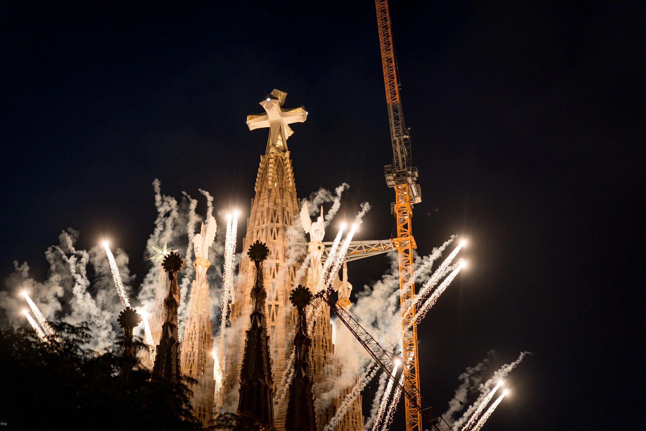 Fuegos artificiales iluminando la Sagrada Familia en Barcelona durante la noche.