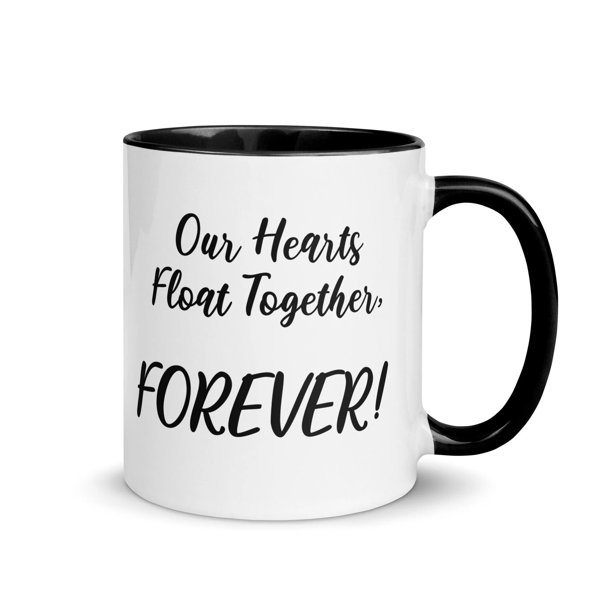 White mug with black handle and interior, printed with the quote 'Our Hearts Float Together, FOREVER!' in black cursive and bold font.