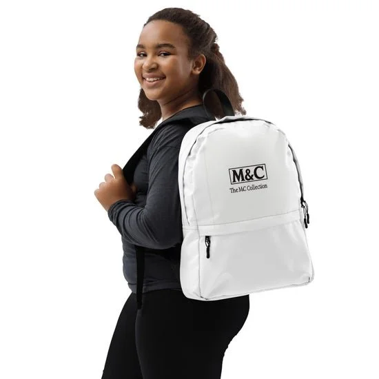 Smiling girl with curly hair in black clothing carrying a white backpack with black text 'M&C The M&C Collection' on a plain white background.
