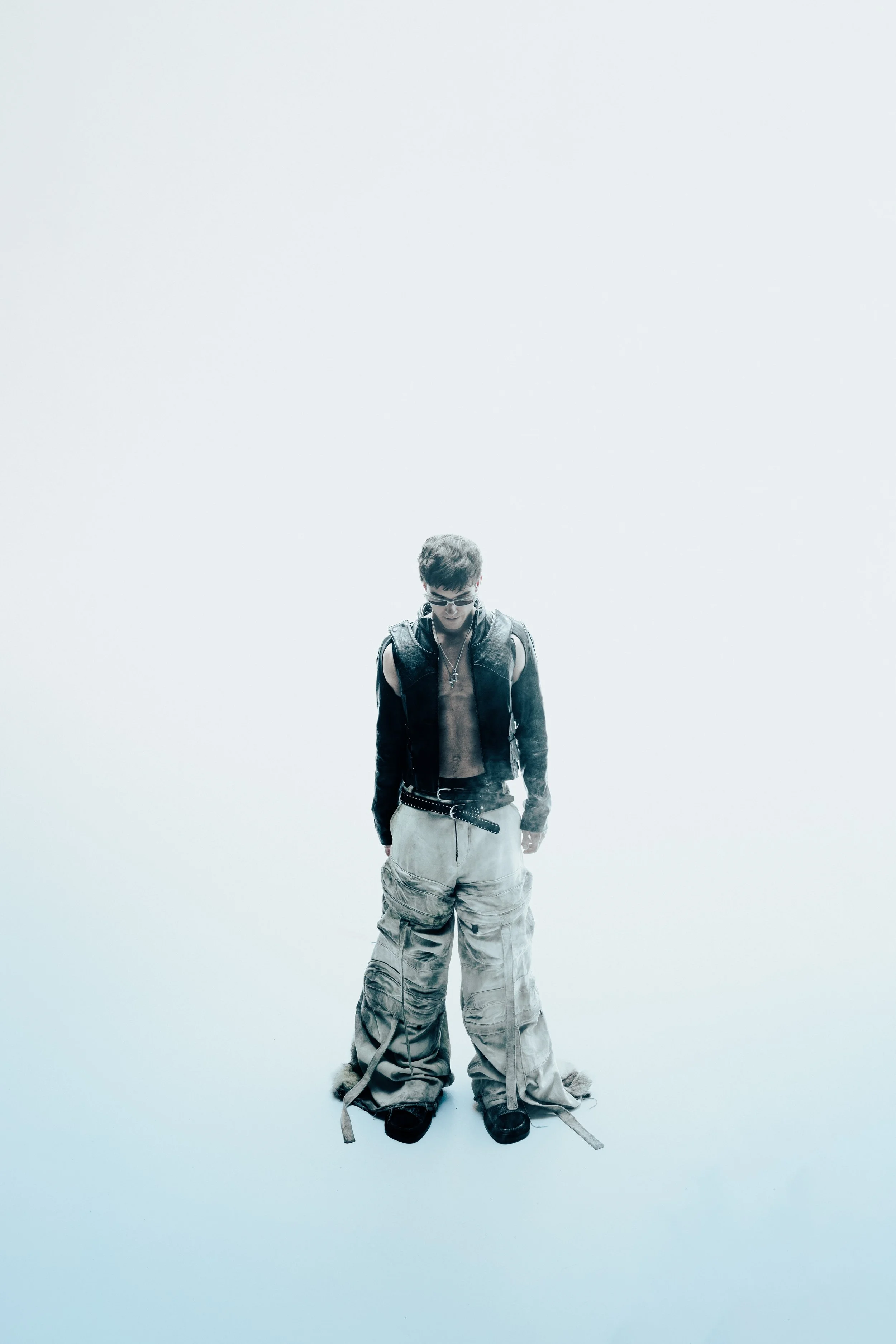 Person wearing a black jacket and baggy cargo pants against a plain light background.