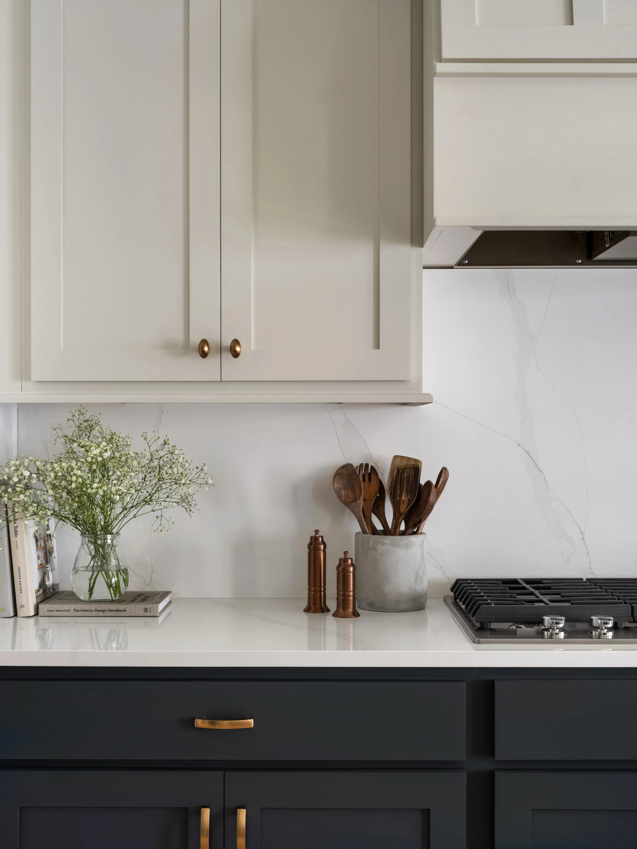 A simple countersplash moment can make such a quiet statement when the surrounding details are considered.
In this kitchen, the clean lines of the cabinetry give the space structure, while the natural texture of the quartz, warm wood tones, and softe