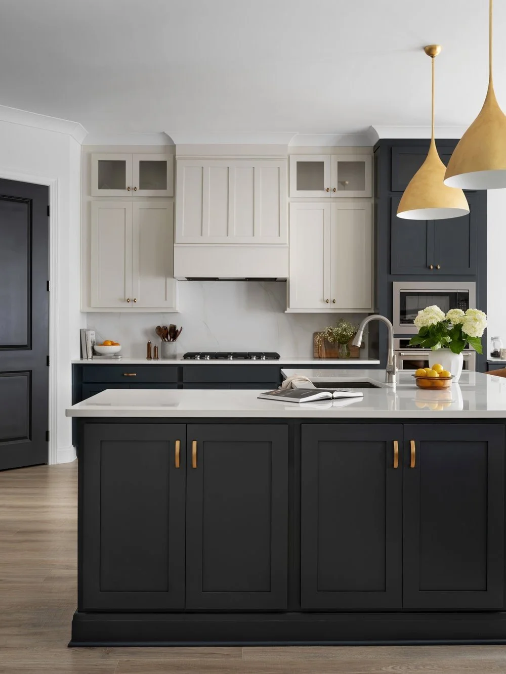 Luxury kitchen backdrop with arched back leather barstools and oversized brass pendants.