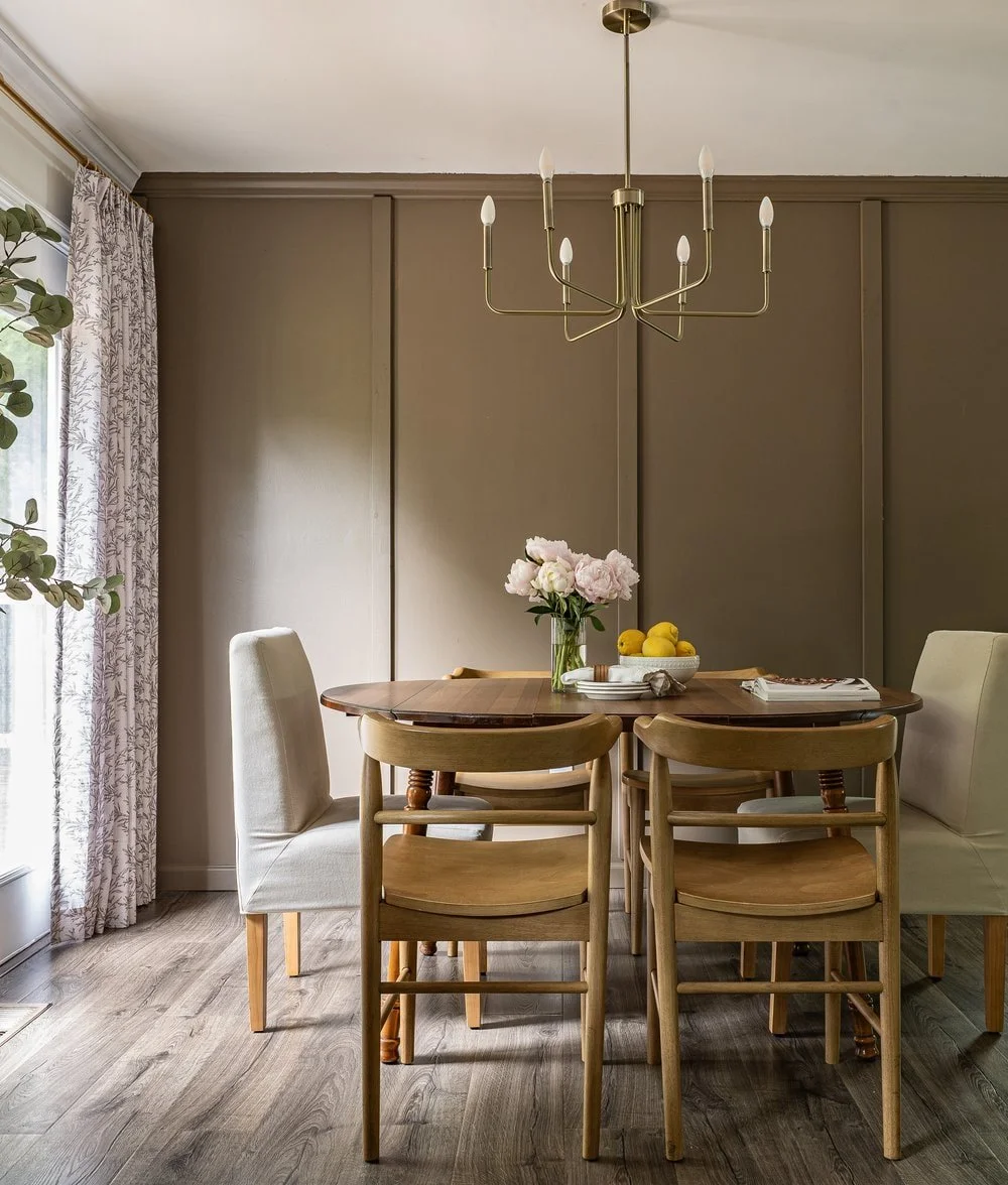 Timeless dining room design with neutral upholstered end chairs, arched back side chairs, and vintage dining table