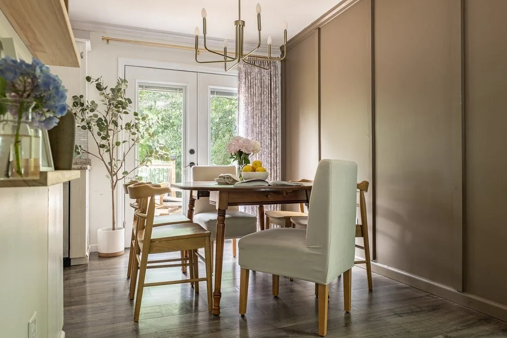 Timeless dining room design with neutral upholstered end chairs, arched back side chairs, and vintage dining table
