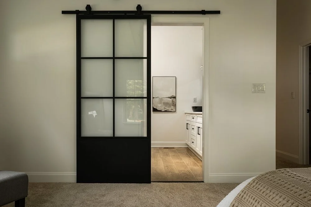 Sliding glass window pane custom door in master bedroom with white clean lines.
