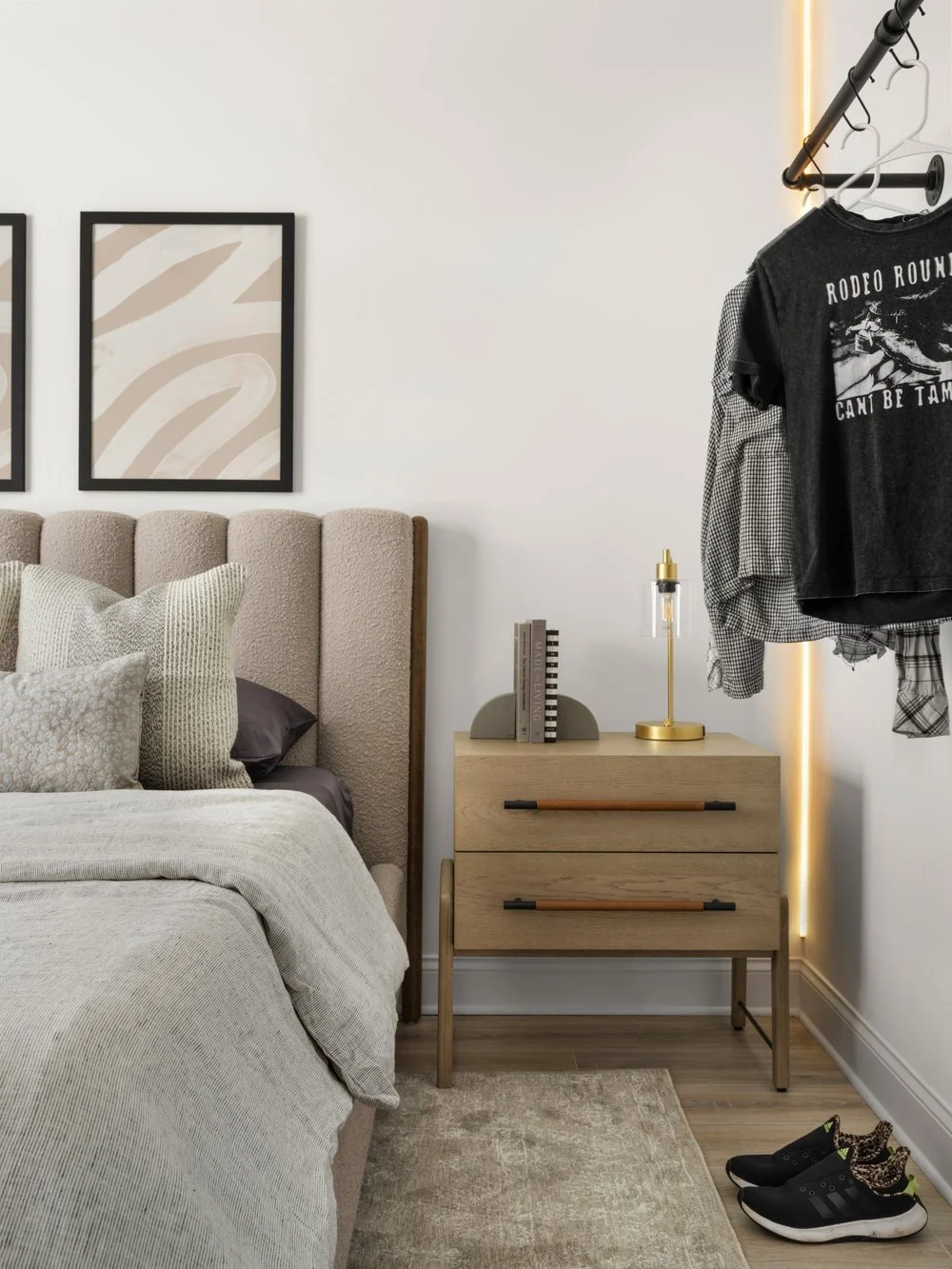 Sophisticated yet fun teen bedroom with a white oak drawer nightstand and neutral channeled headboard. Custom wall mounted clothing rack for teen fashion choices are on the right