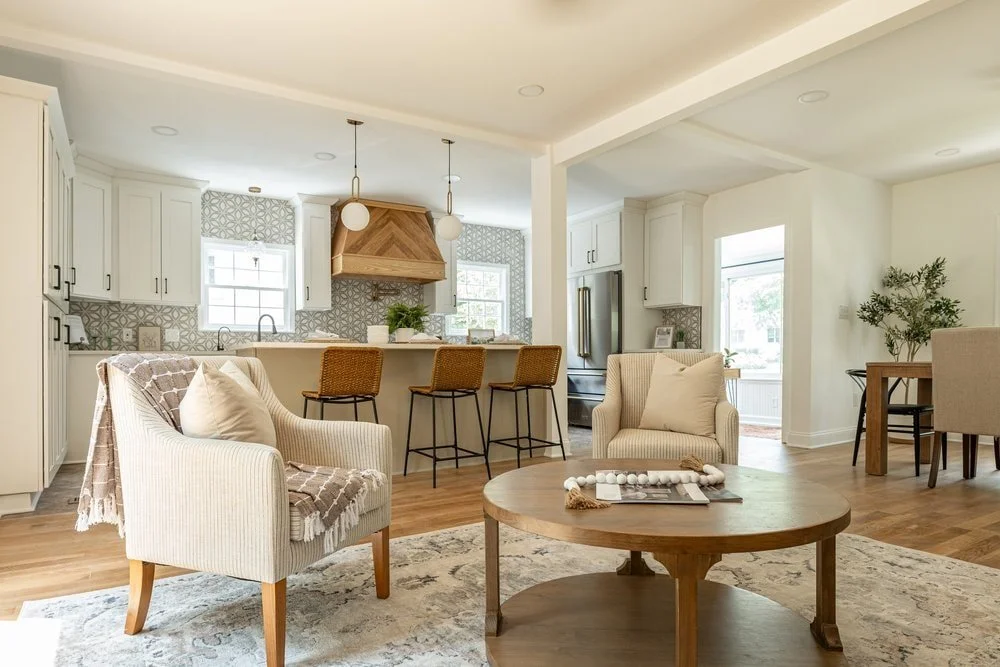 Luxury custom kitchen in Georgia with a sitting area adjacent with two oversized striped club chairs and woven bar stools