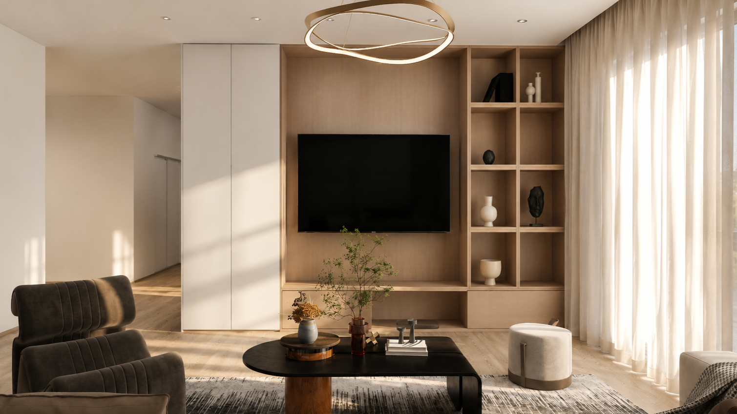 SK Studio Design - Custom Modern living room with light wood shelving unit, wall-mounted flat-screen TV, black coffee table with decorative items, brown armchairs, a white ottoman, and sheer curtains letting in natural light.