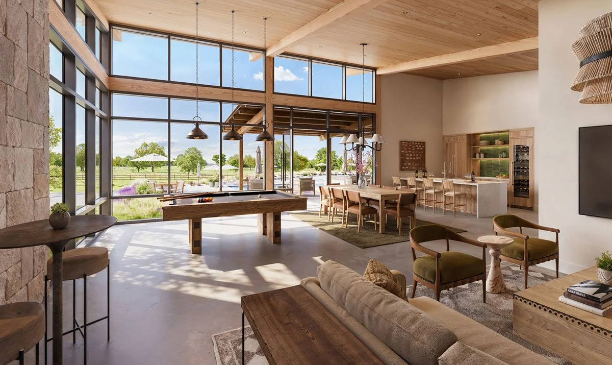 Interior of a modern, spacious living area with large windows overlooking a green outdoor landscape, featuring a pool table, a dining area, and a kitchen with bar stools.