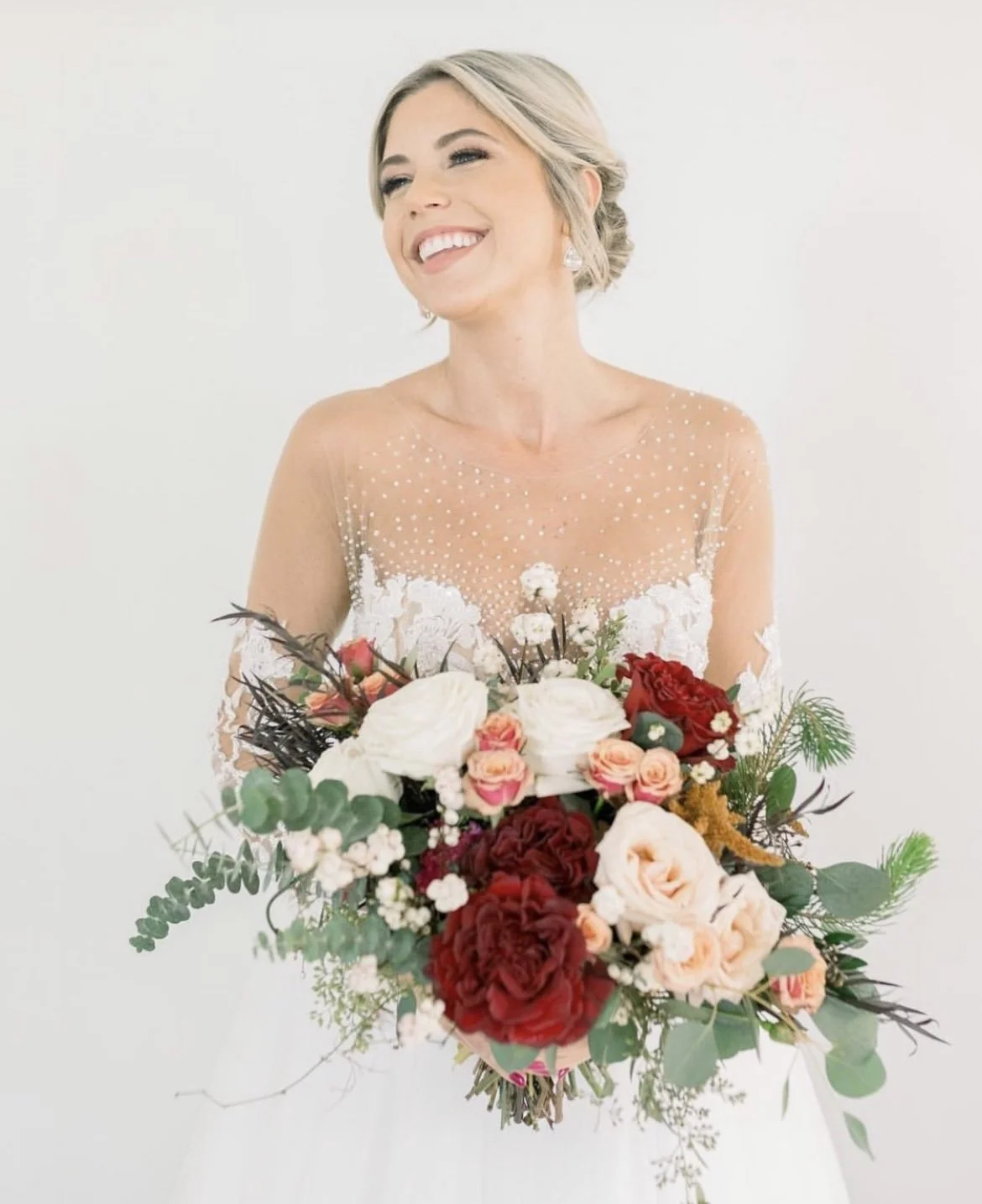 A woman in a wedding dress holding a bouquet of flowers.