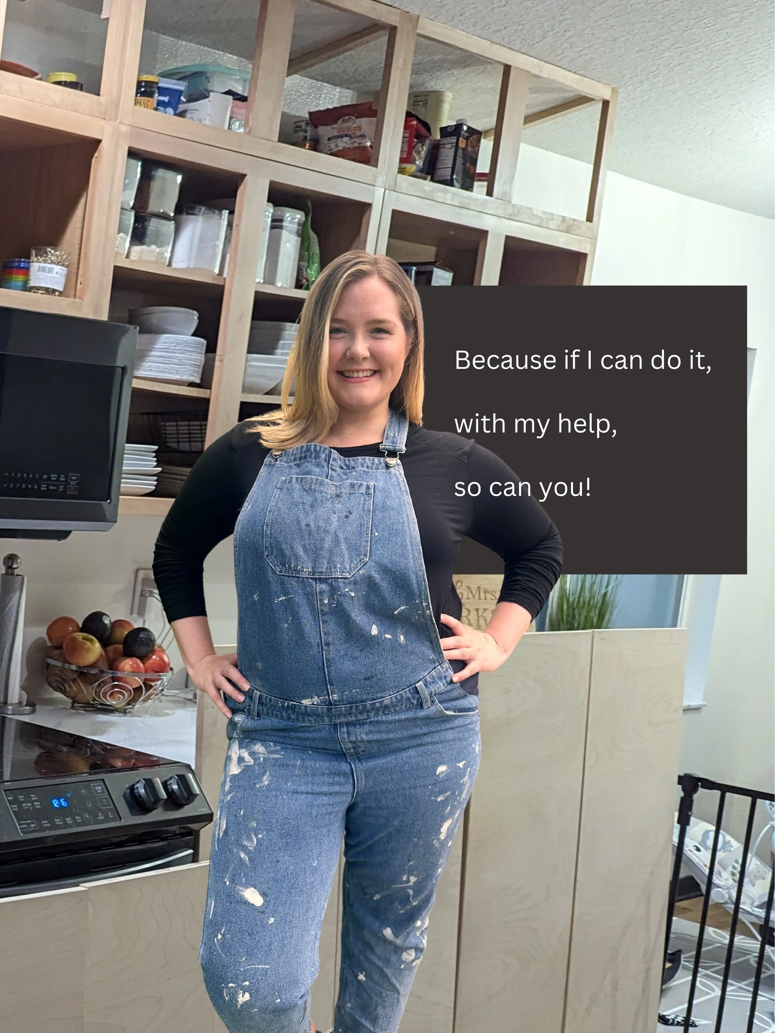 A woman standing in a kitchen wearing a black shirt and paint-stained denim overalls. She is smiling with her hands on her hips. The kitchen has wooden shelves with various items, a bowl of apples, and a stove. There is a text box with the words 'Bec