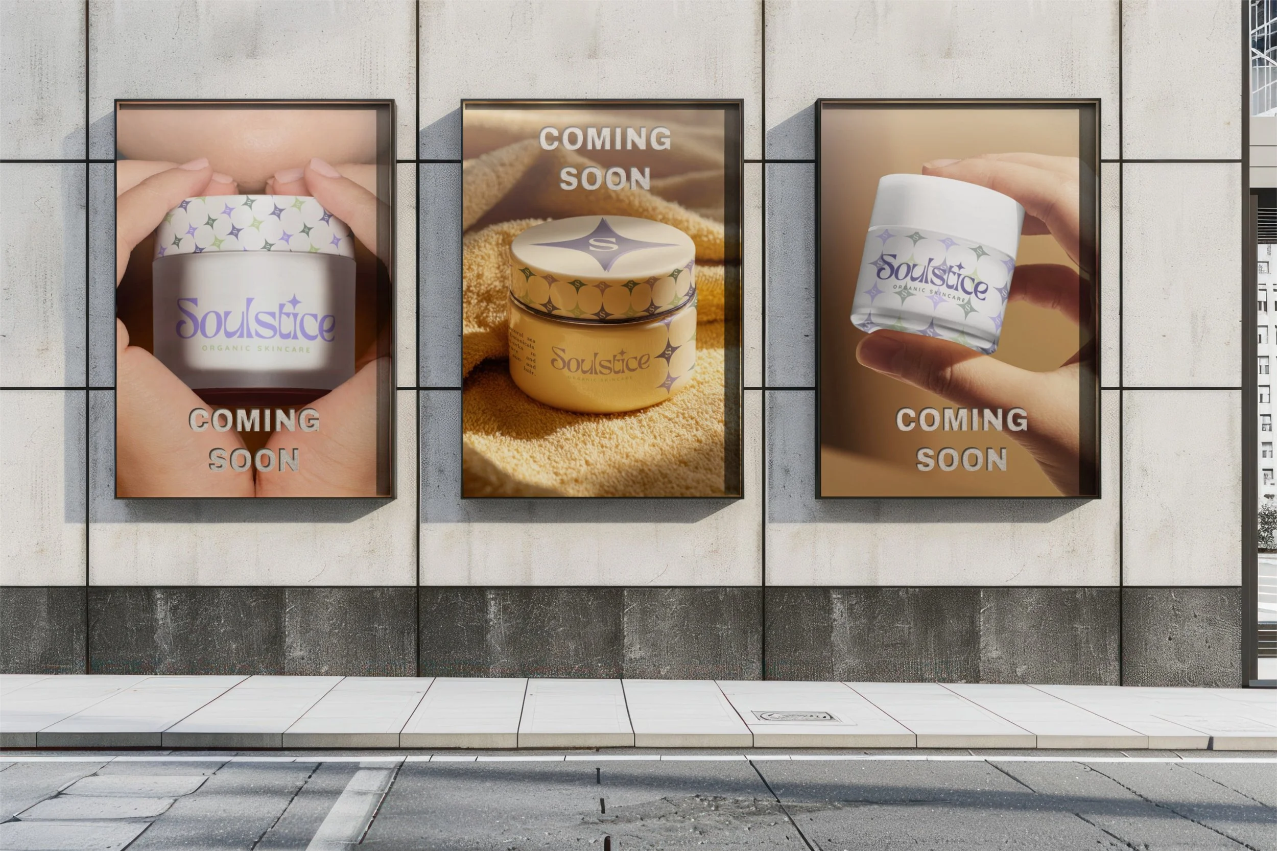 Three posters on a building wall promoting skincare products with the brand name 'Soulstice'. The first and third posters show hands holding jars of the product labeled 'Soulstice' with 'COMING SOON' text. The middle poster features a close-up of two