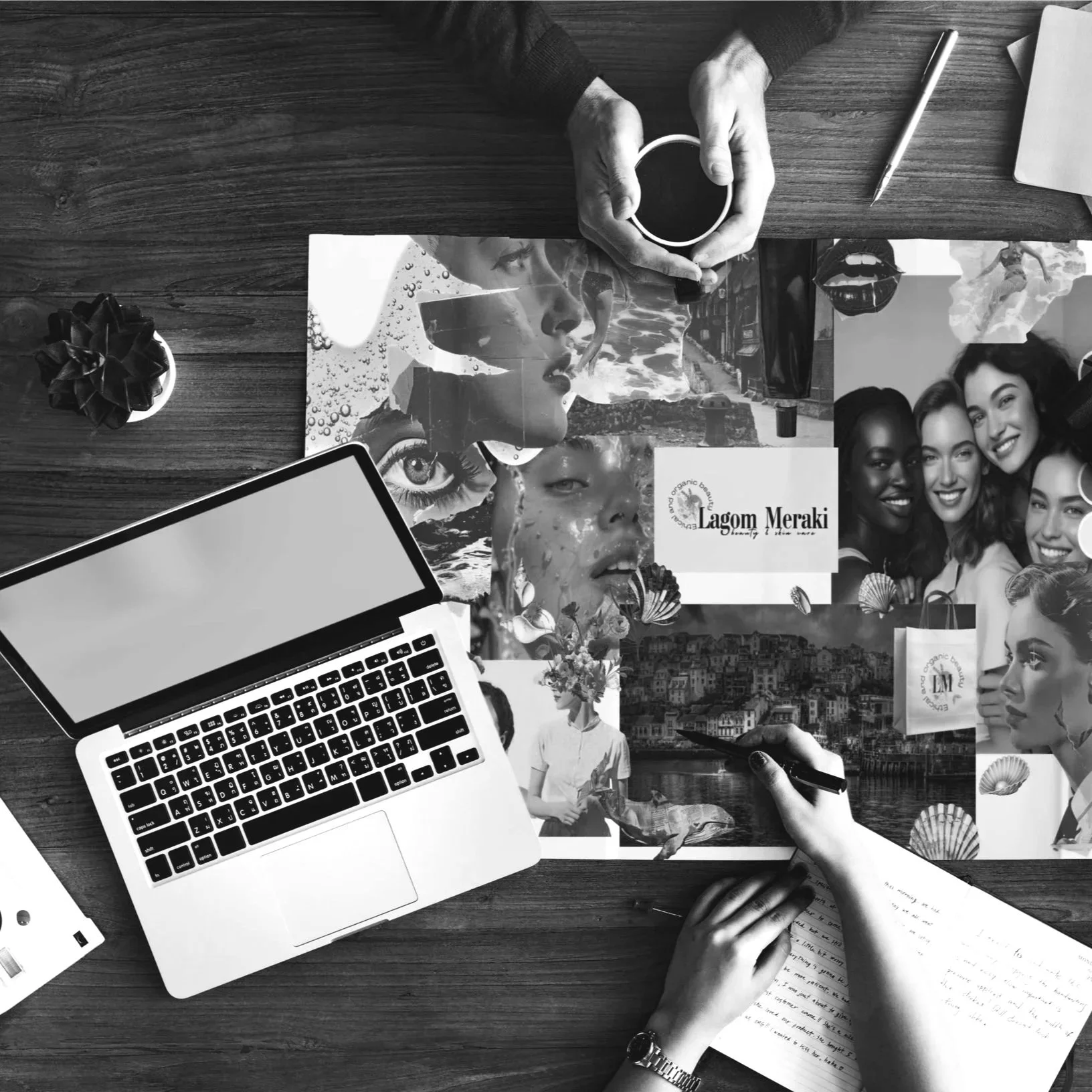 Black and white photo of a workspace featuring a laptop, USBA flash drive, paper with handwriting, collage of images including faces, water, and scenery, a person's hand writing on paper, a coffee cup held by another person, a pen, and a small potted plant.