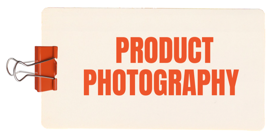 A white clipboard with red clip held by an orange binder clip, displaying the text "PRODUCT PHOTOGRAPHY" in bold red letters.