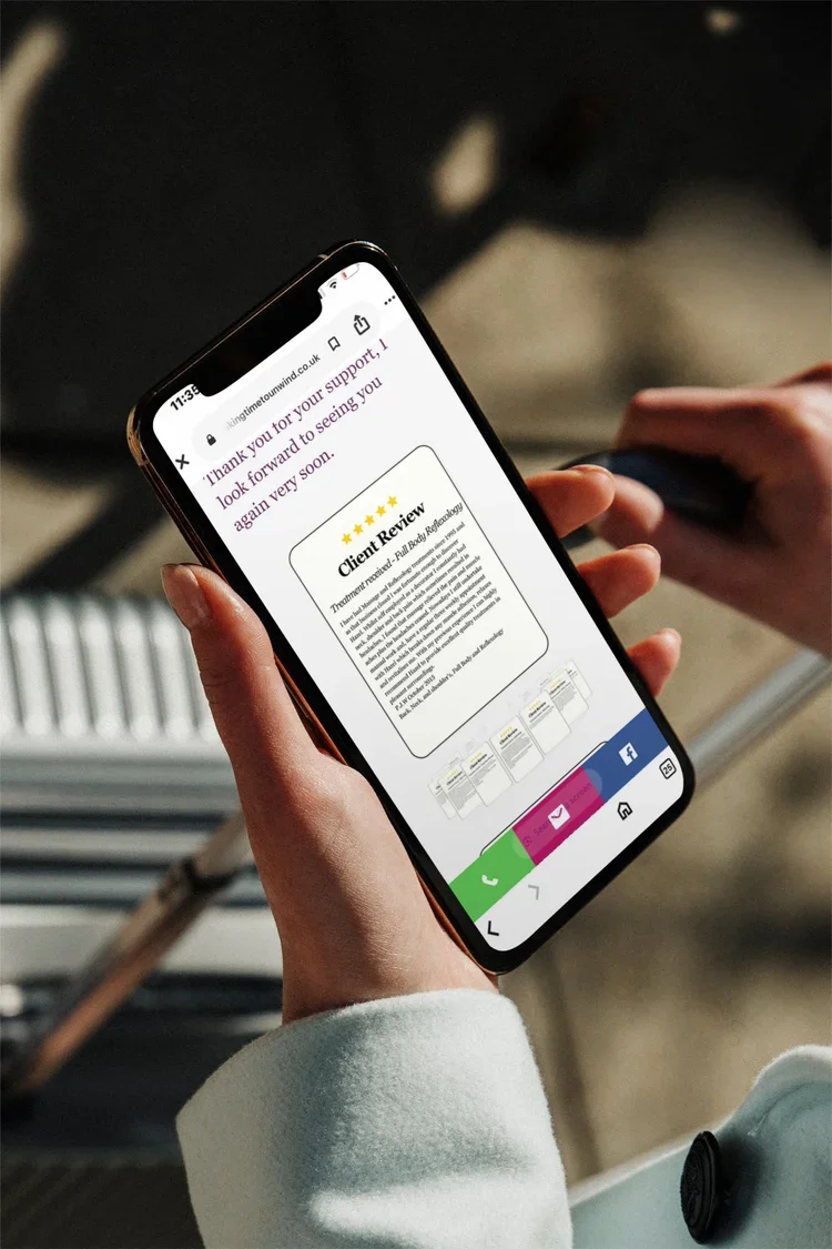 Person holding a smartphone displaying a customer review webpage with a 5-star rating and a thank you message, in an indoor setting.