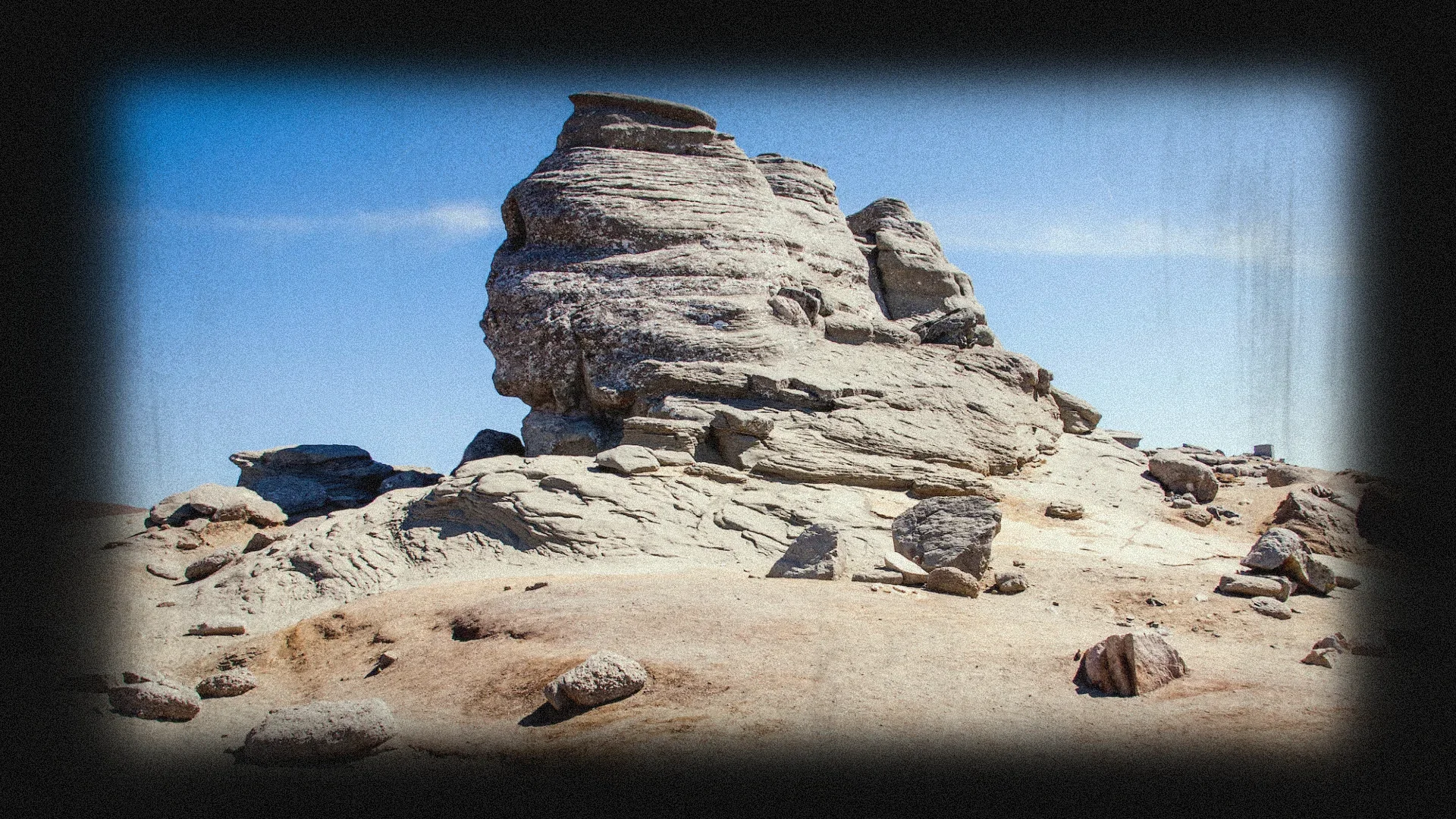 Sphinx rock formation in a desert landscape under a blue sky
