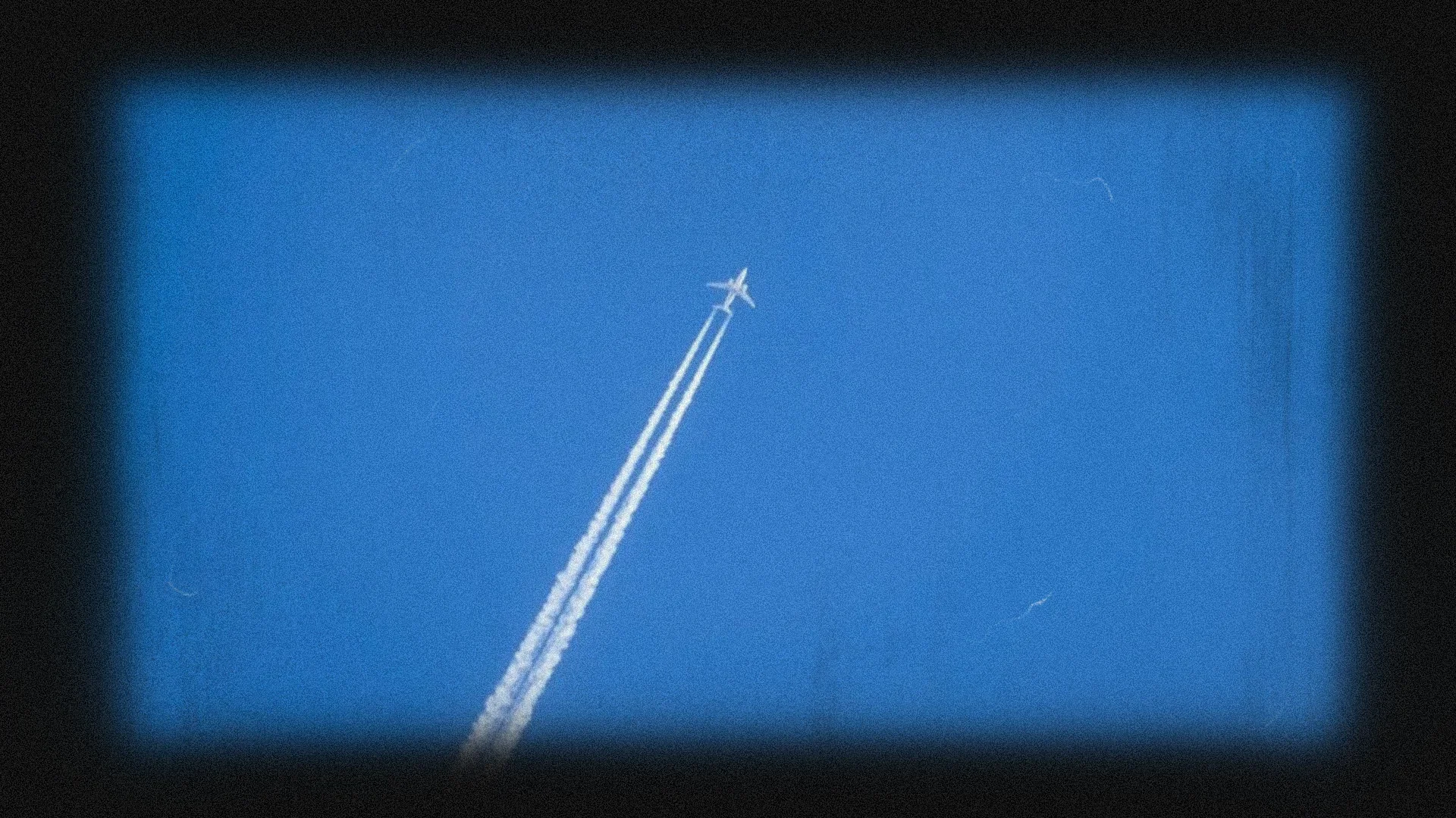 Airplane flying in blue sky with contrails