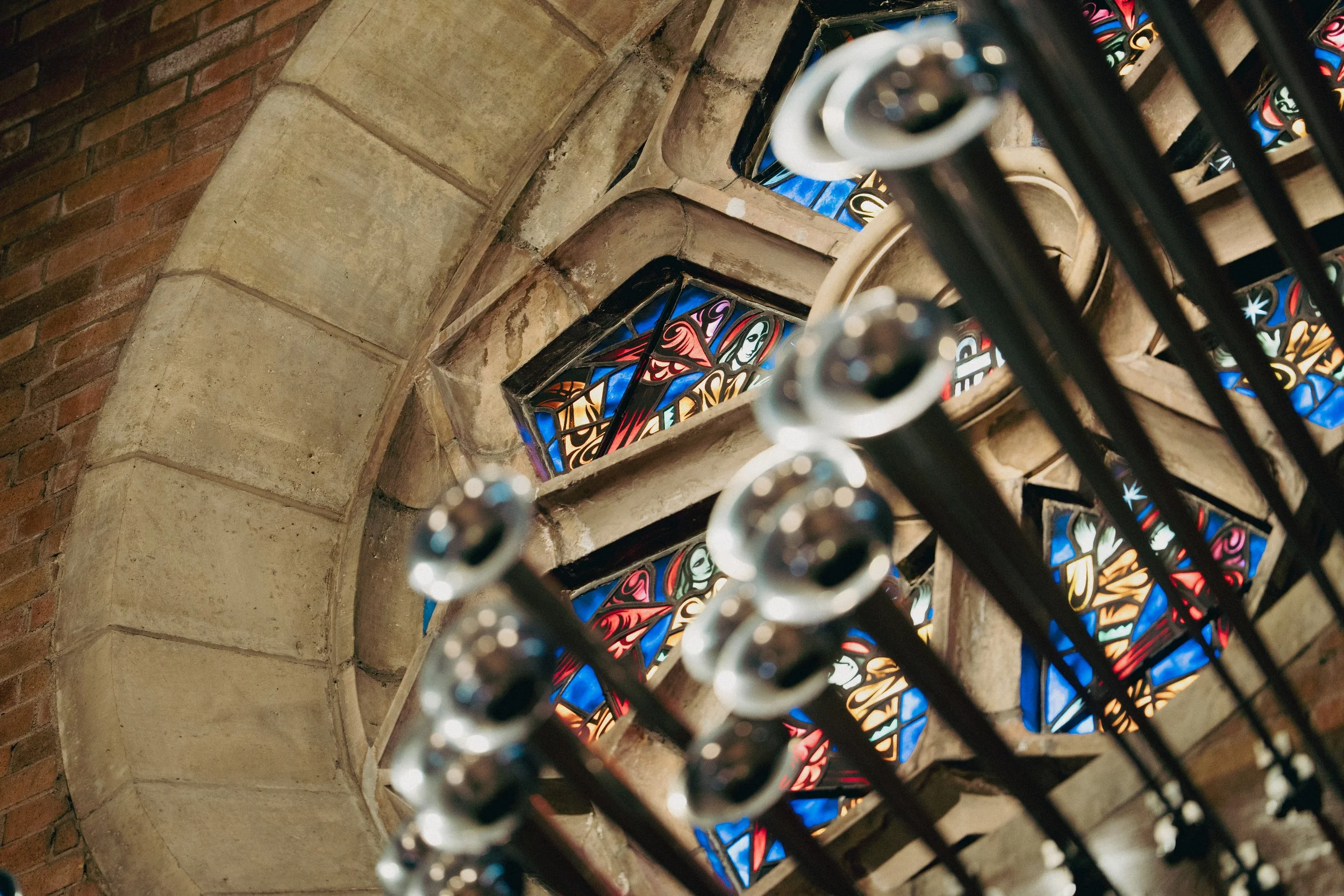 Close up view of the stained glass in the rose window and the trumpets underneath it.