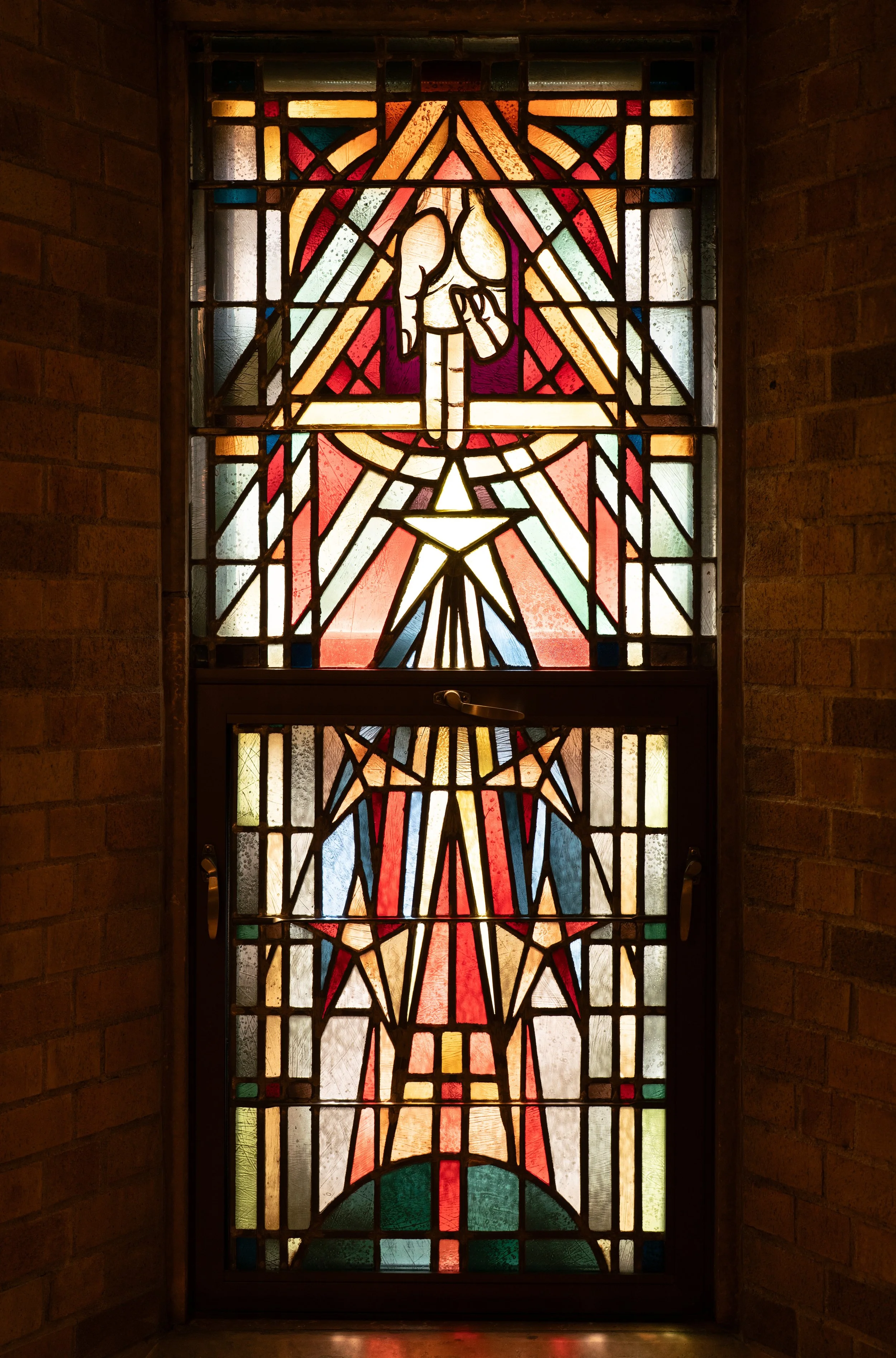 Colorful stained glass window depicting the hand of the Father.