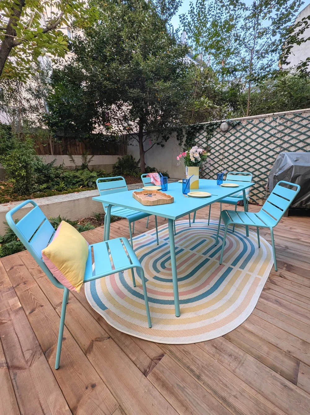 Colourful garden set and geometric cushions and rug on a terrasse styled by Rainbow Shaker