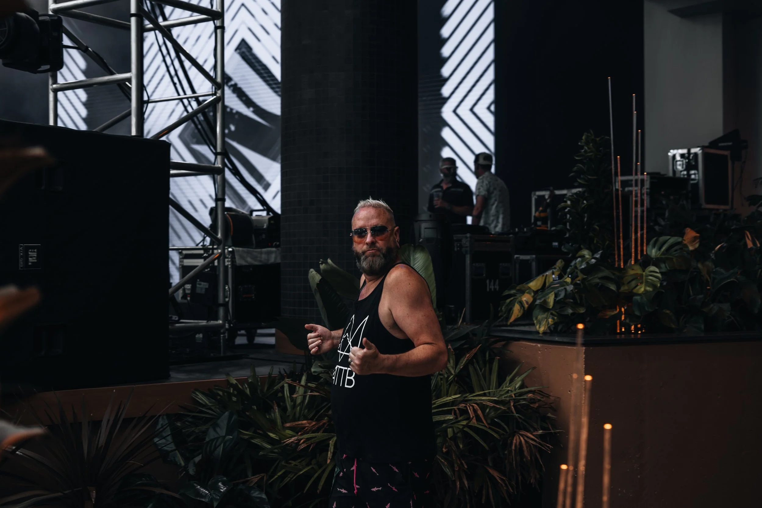 A DJ with tattoos, mattb and collin chaos console in a dark club environment. artist prominent dj grand rapids ready for bookings and big festivals, artist, founder remedy collective djs sound production morris media byron morris wawye oasis