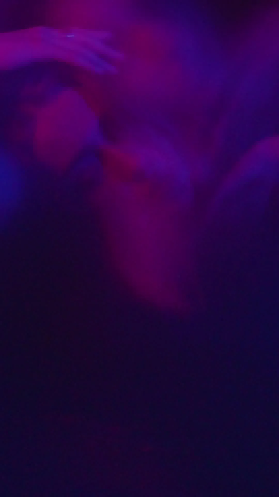 Blurry abstract purple and pink lights against a dark background.