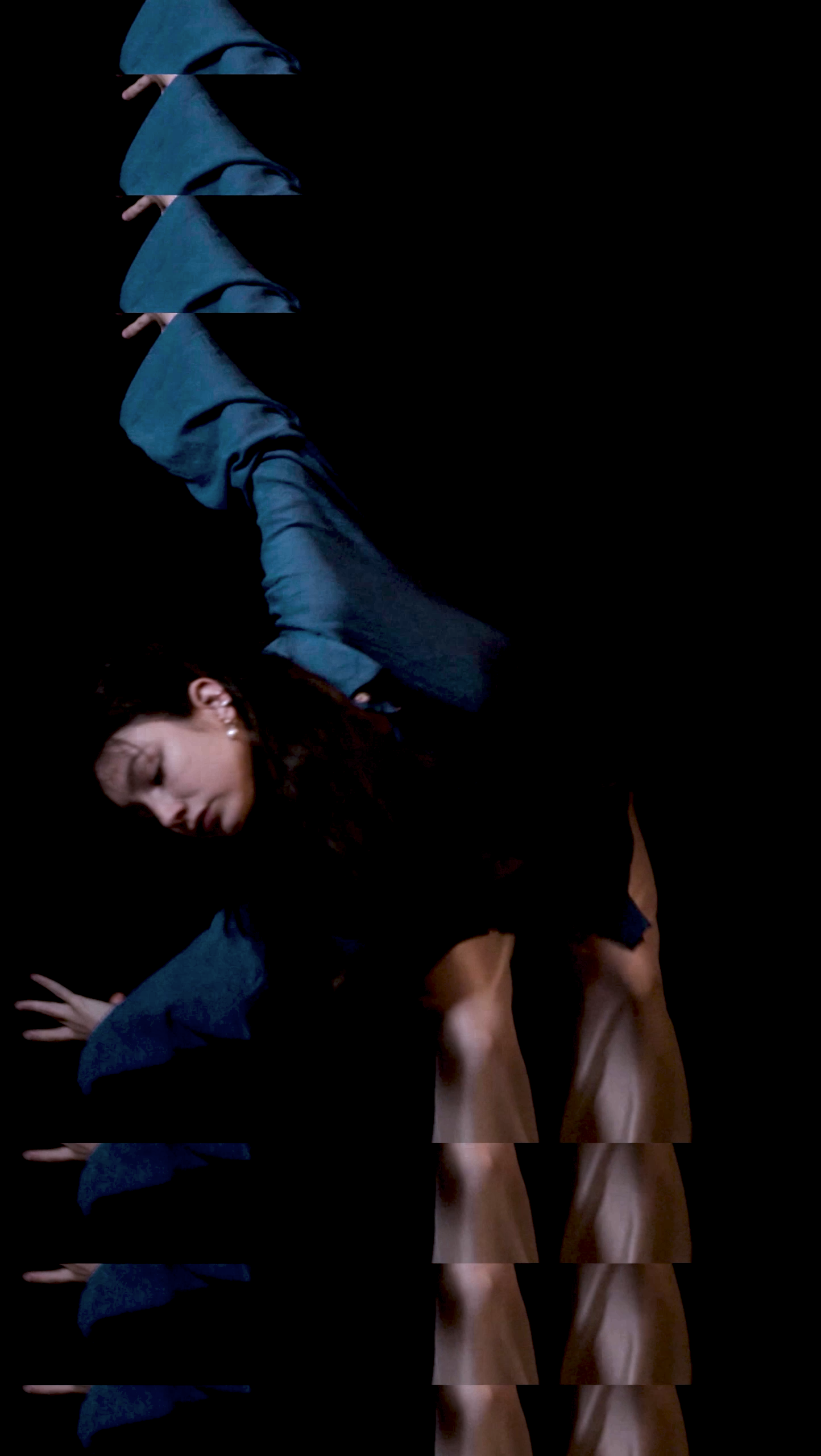 A woman with dark hair, dressed in dark clothing, is bending down with her eyes closed against a black background. The image appears to be distorted with multiple horizontal slices creating a glitch effect.