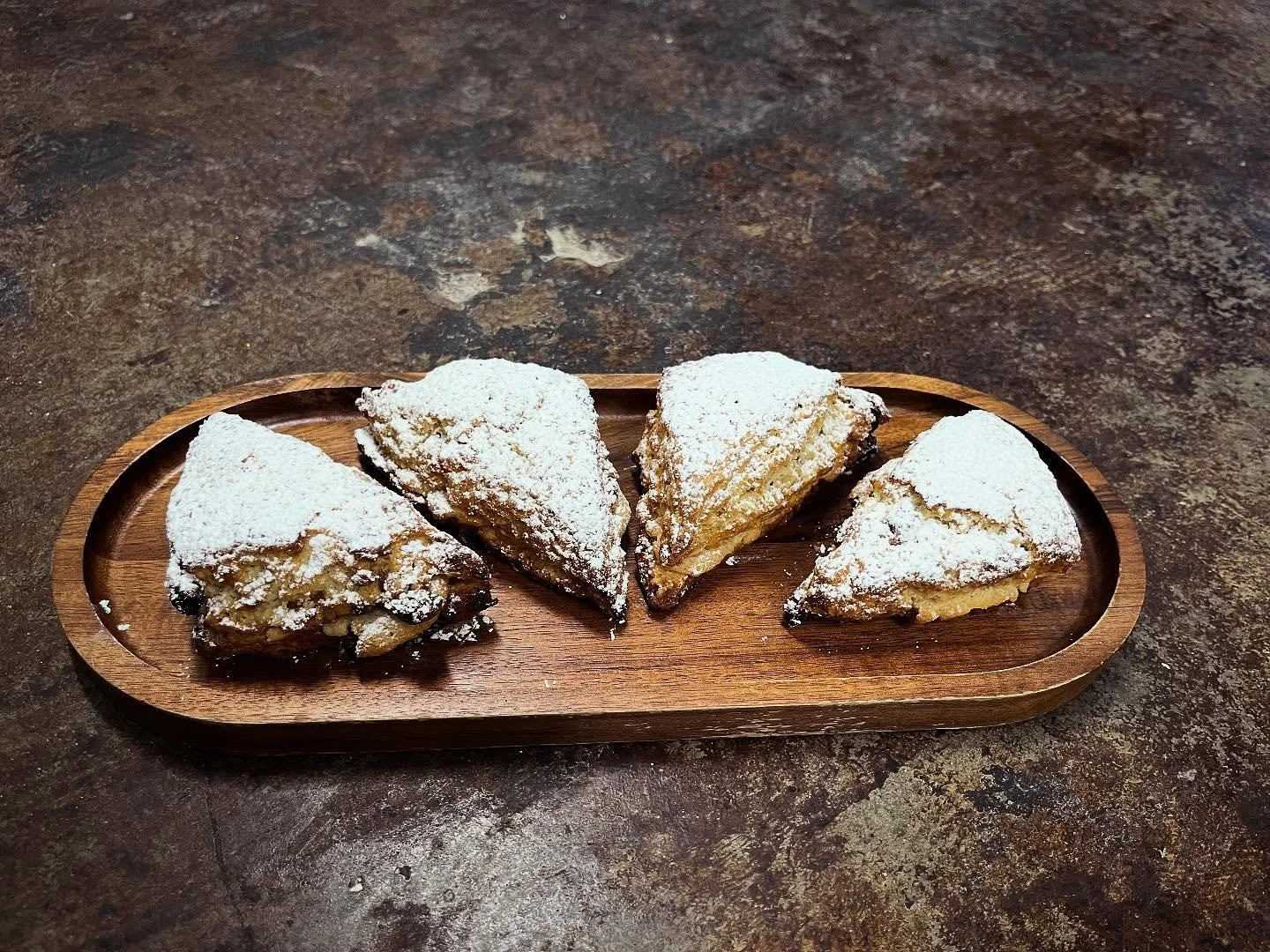 New in the bakery: stollen scones! Inspired by the German bread, our almond cream filled scones are studded with dried cherries, candied oranges, golden raisins and toasted almond slivers, and finished with a dusting of powdered sugar. Available thro