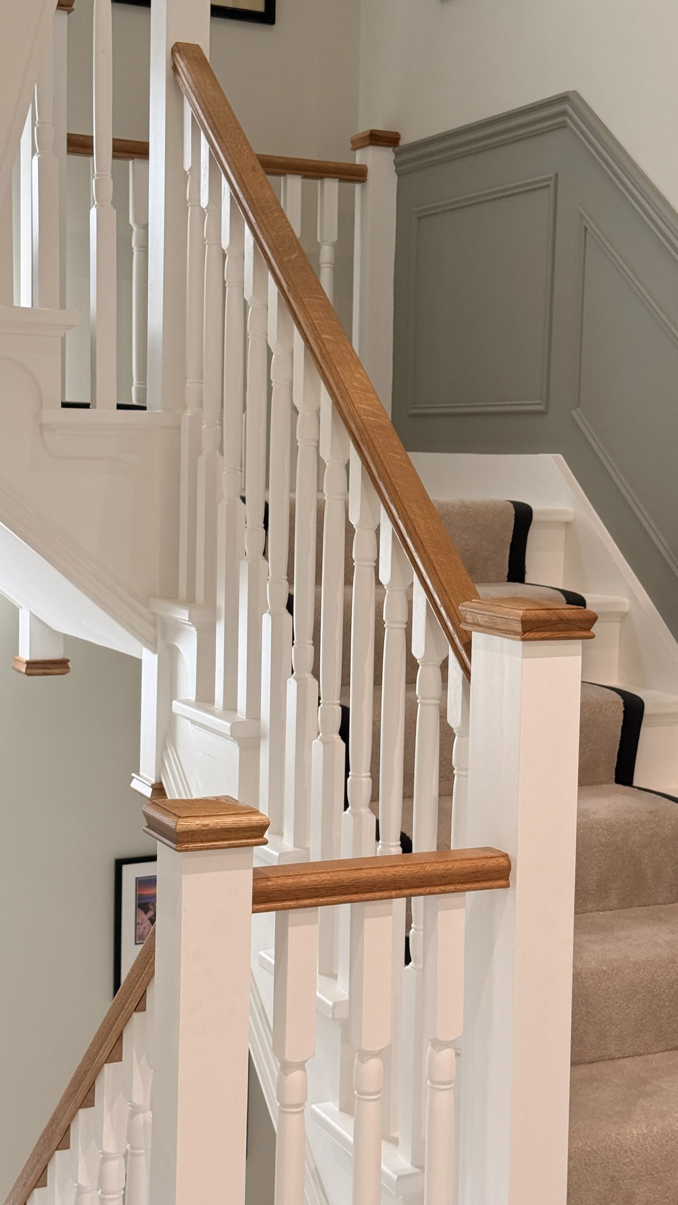 Modern wooden staircase with glass railing in a bright interior.