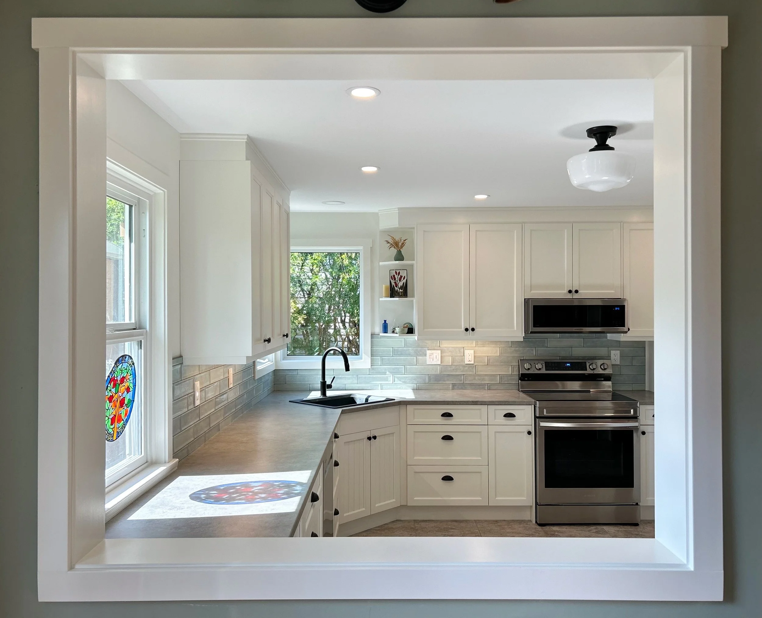 Kitchen installation and new kitchen cabinets. White cabinets, laminate countertop, new trim, black sink, corner sink, stainless steel appliances. Smithers home renovations. Smithers kitchen installation. Smithers kitchen contractor.