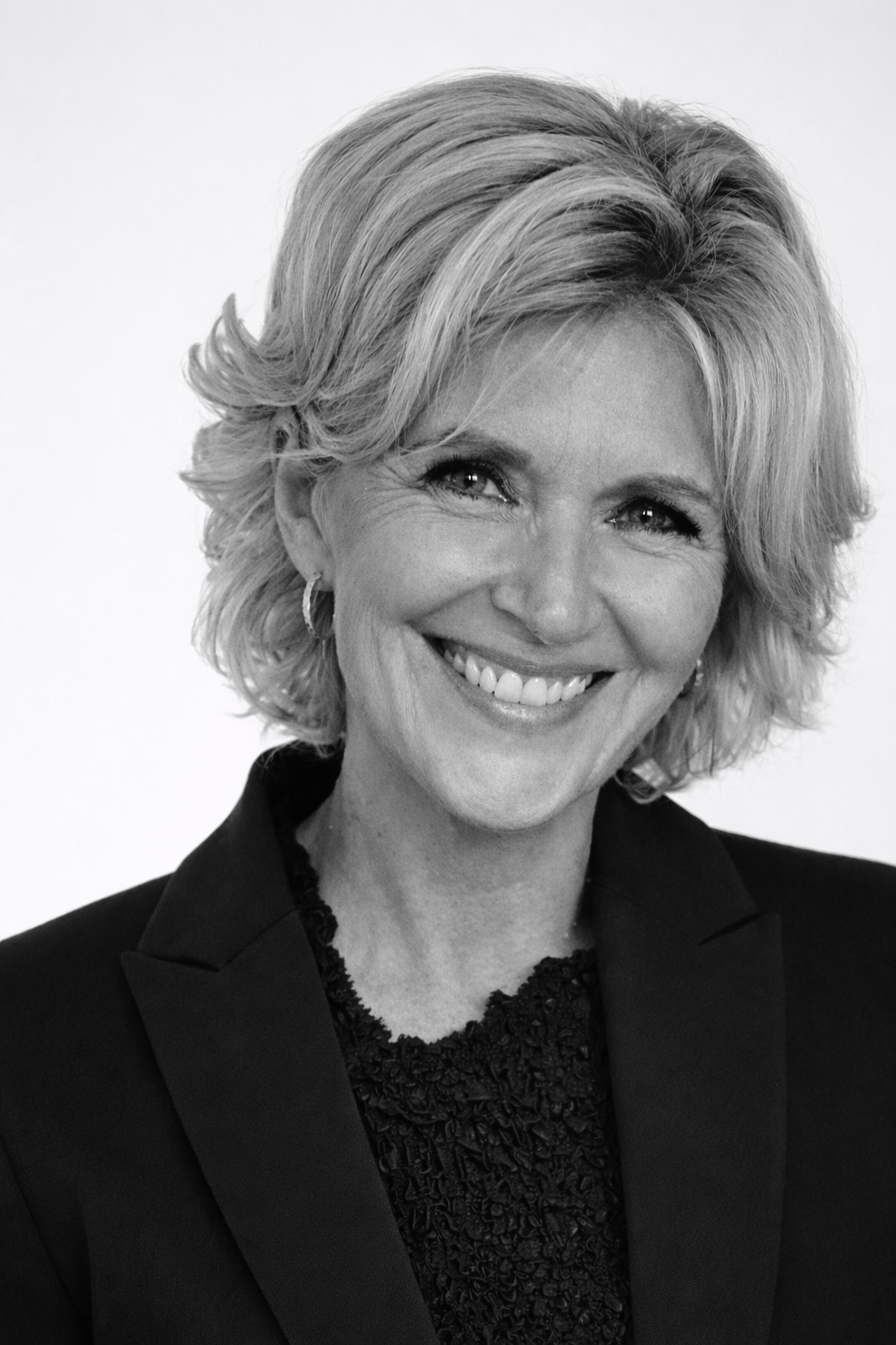 Black and white photo of a smiling man in a suit and tie