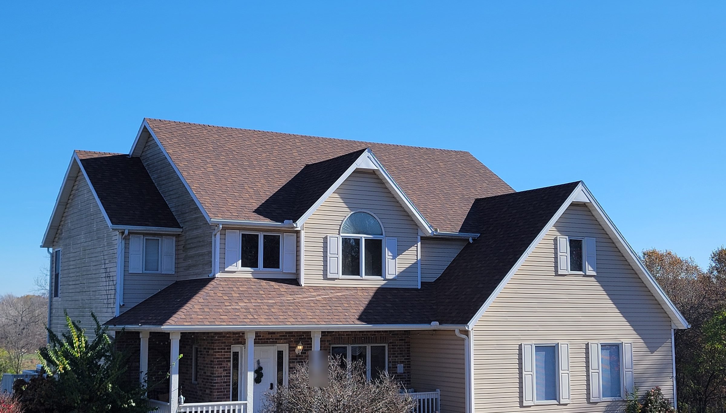Completed architectural asphalt shingle roof on a two-story home