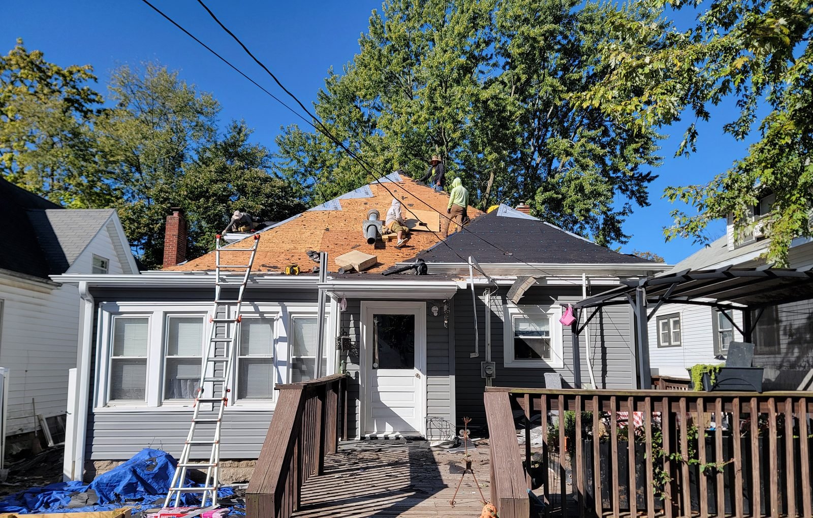 Roofing crew working on the roof of a one-and-a-half-story home