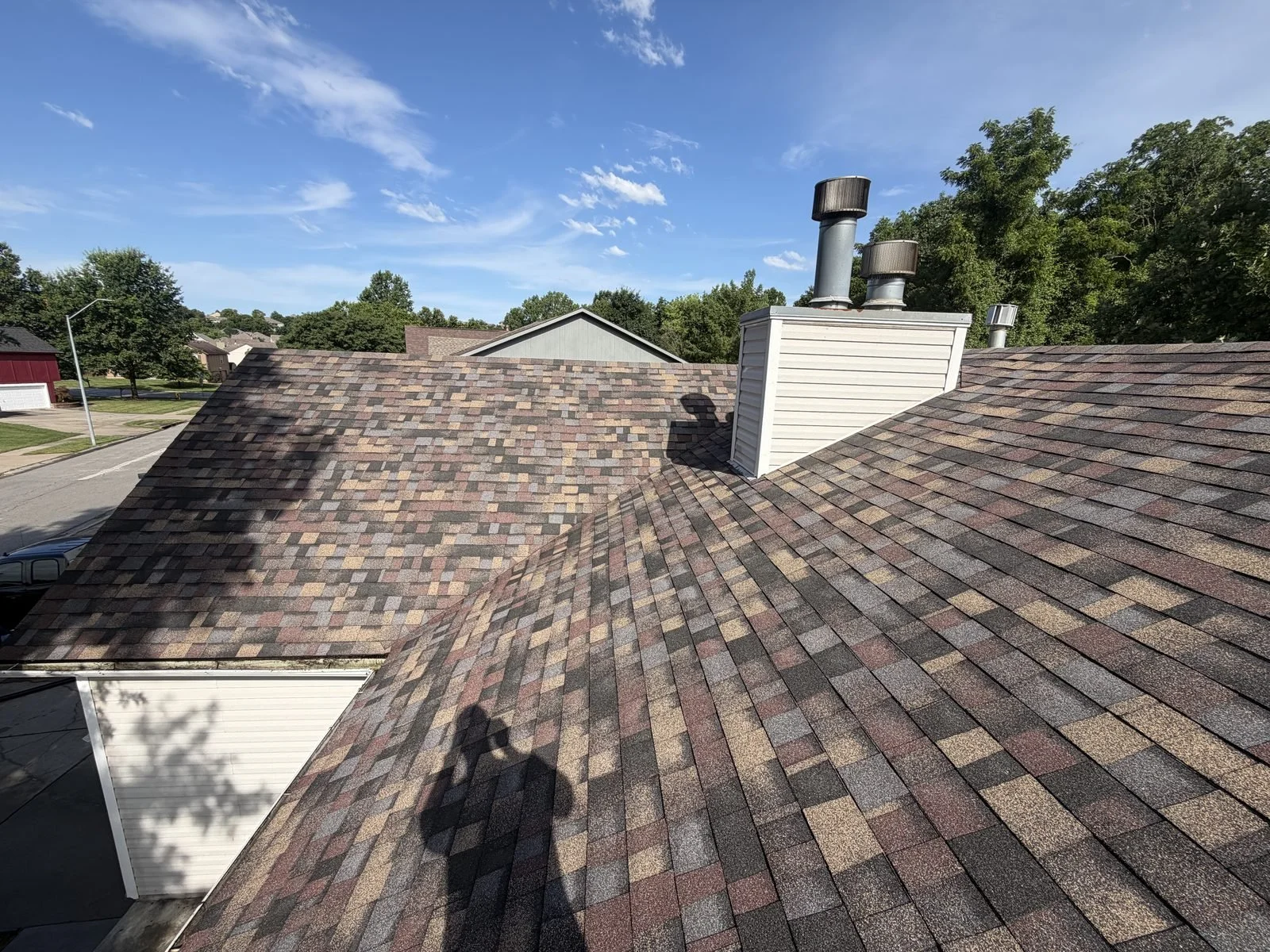 New architectural shingle roof installed around a chimney