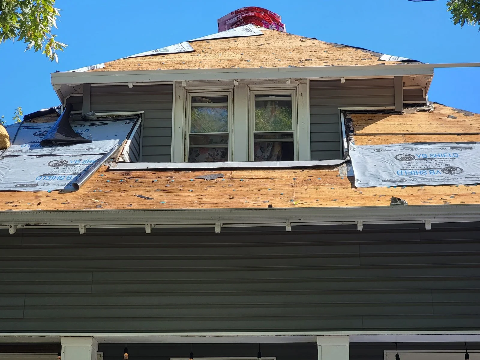 New roof sheathing installed on a dormer during a roof replacement