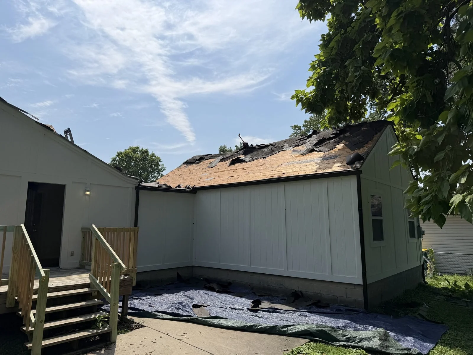 Roof tear-off in progress with decking exposed on a single-story home