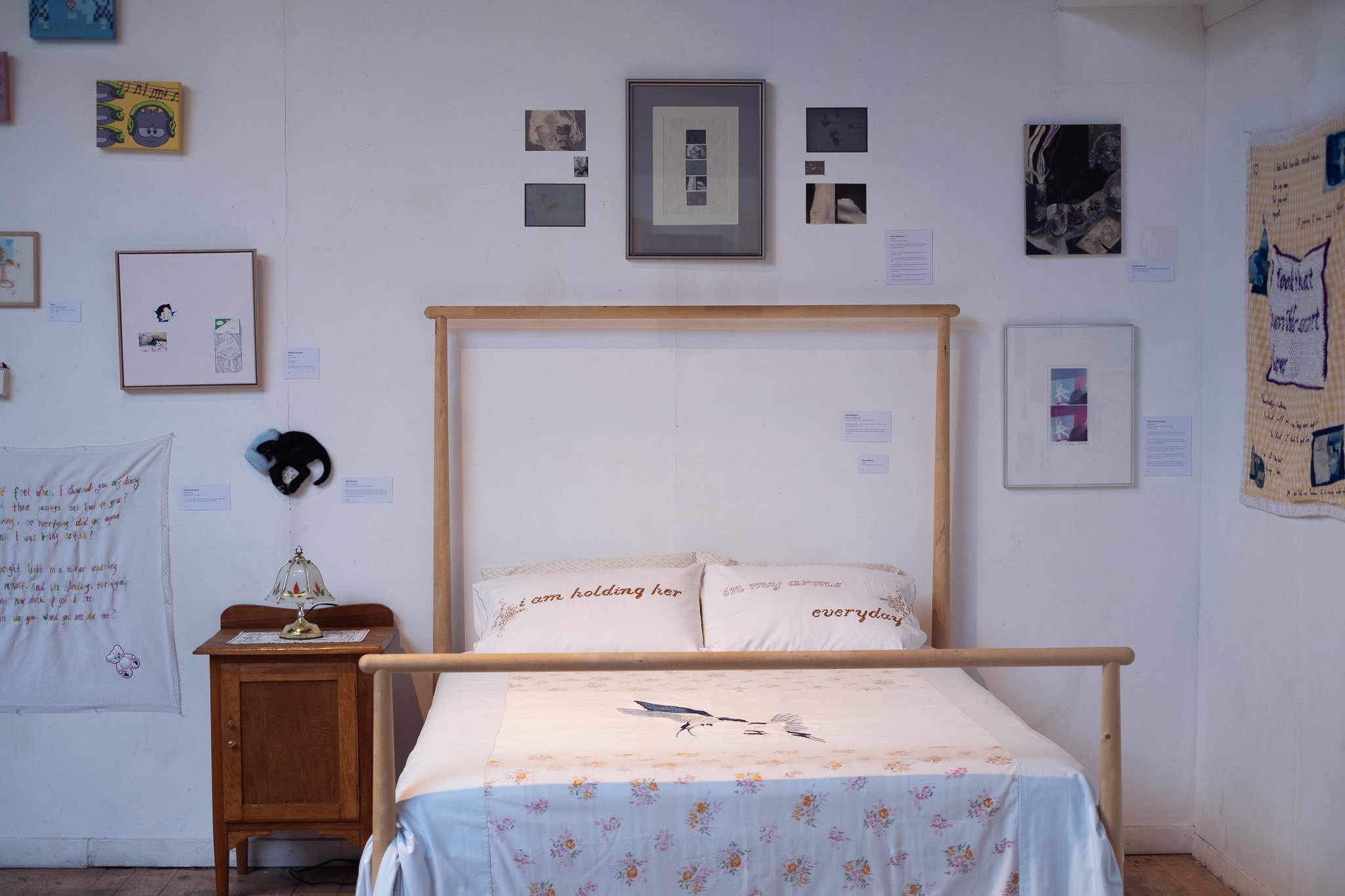 An image of Nina Seeburg's Forever Bedroom, featuring a bed surrounded by frames.
