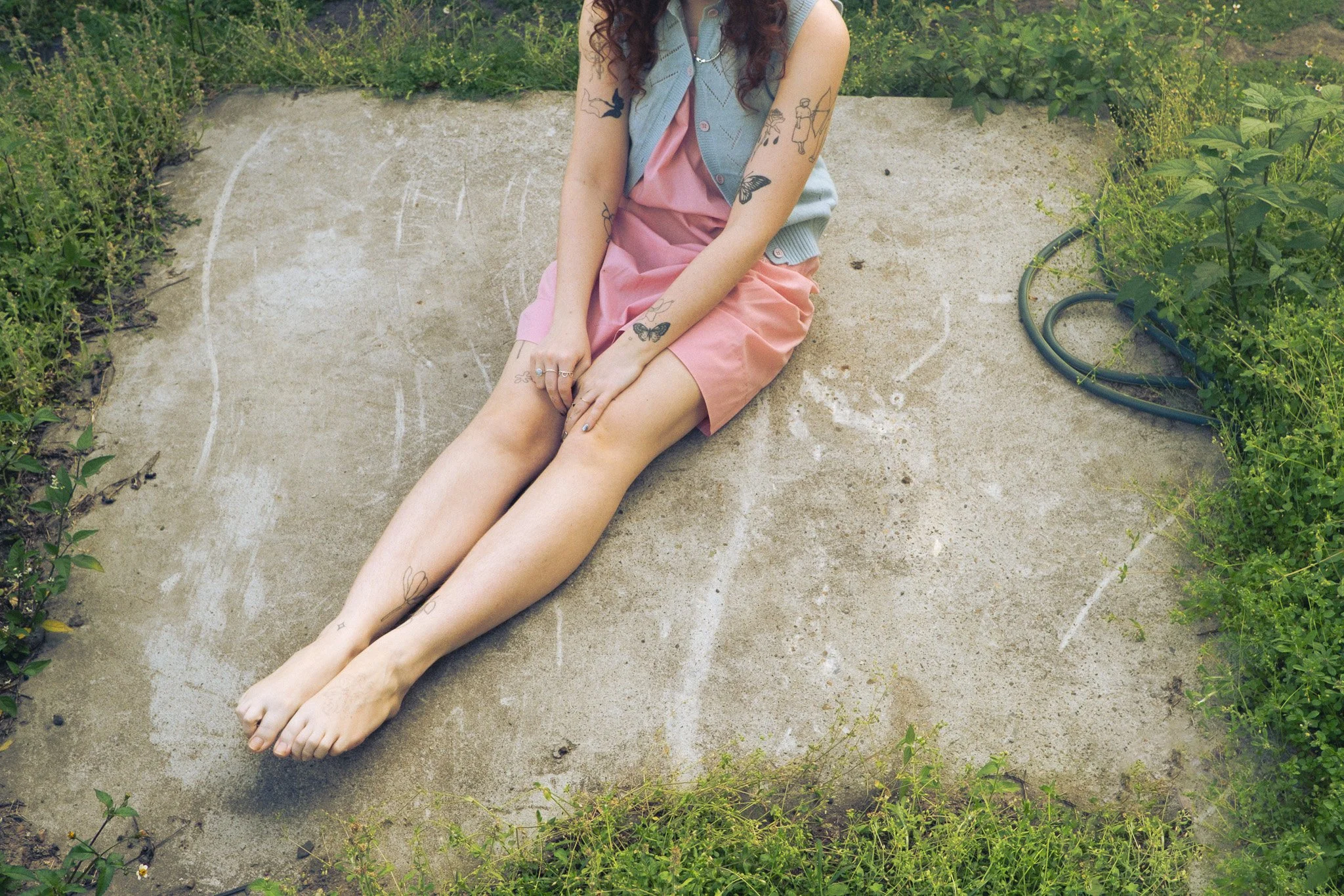 A photo by Selina Vicenzino of someone sitting outdoors with their legs outstretched.