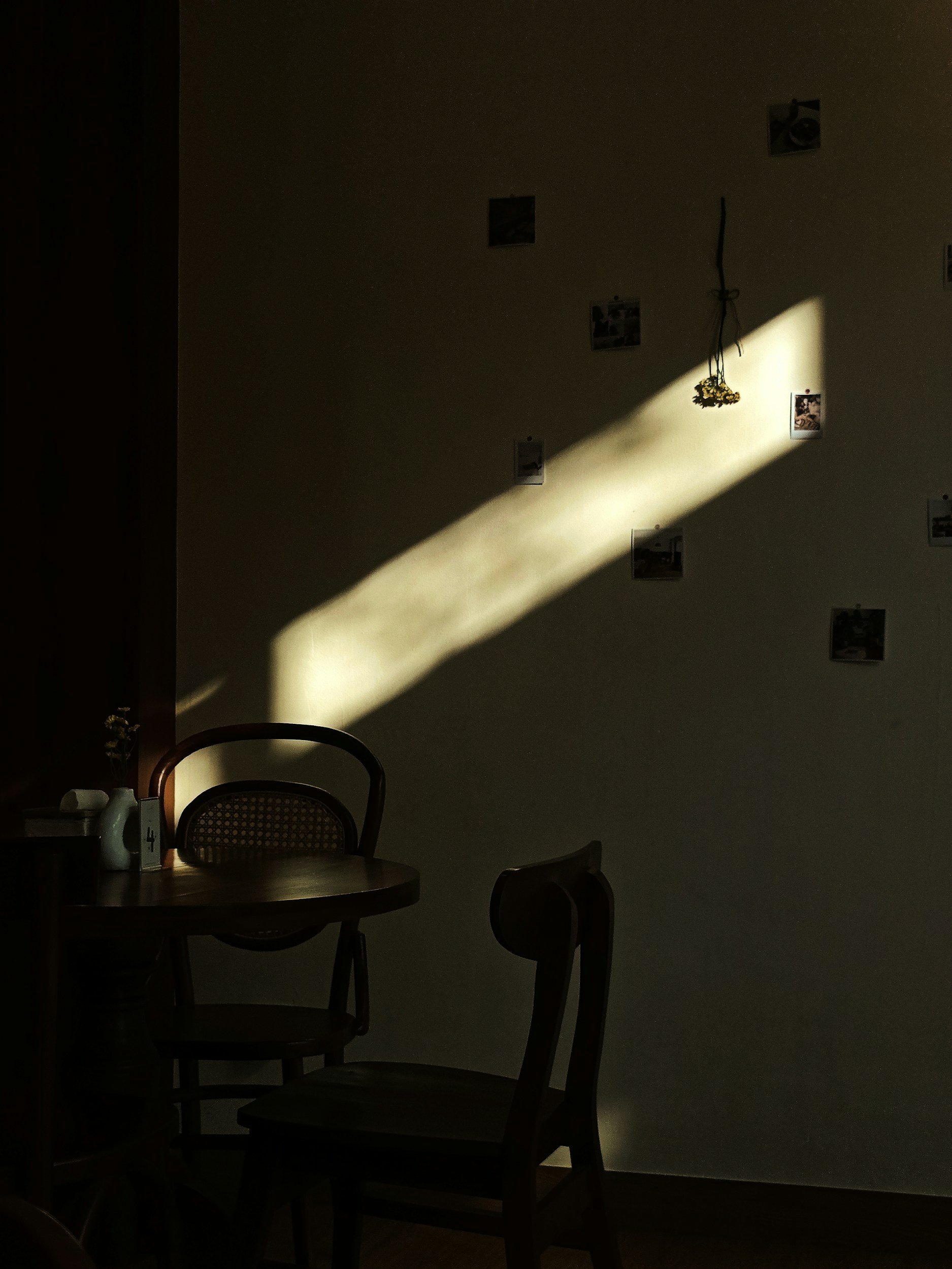Soft light streaming across a quiet room with chairs and a table, representing nervous system safety and emotional processing.