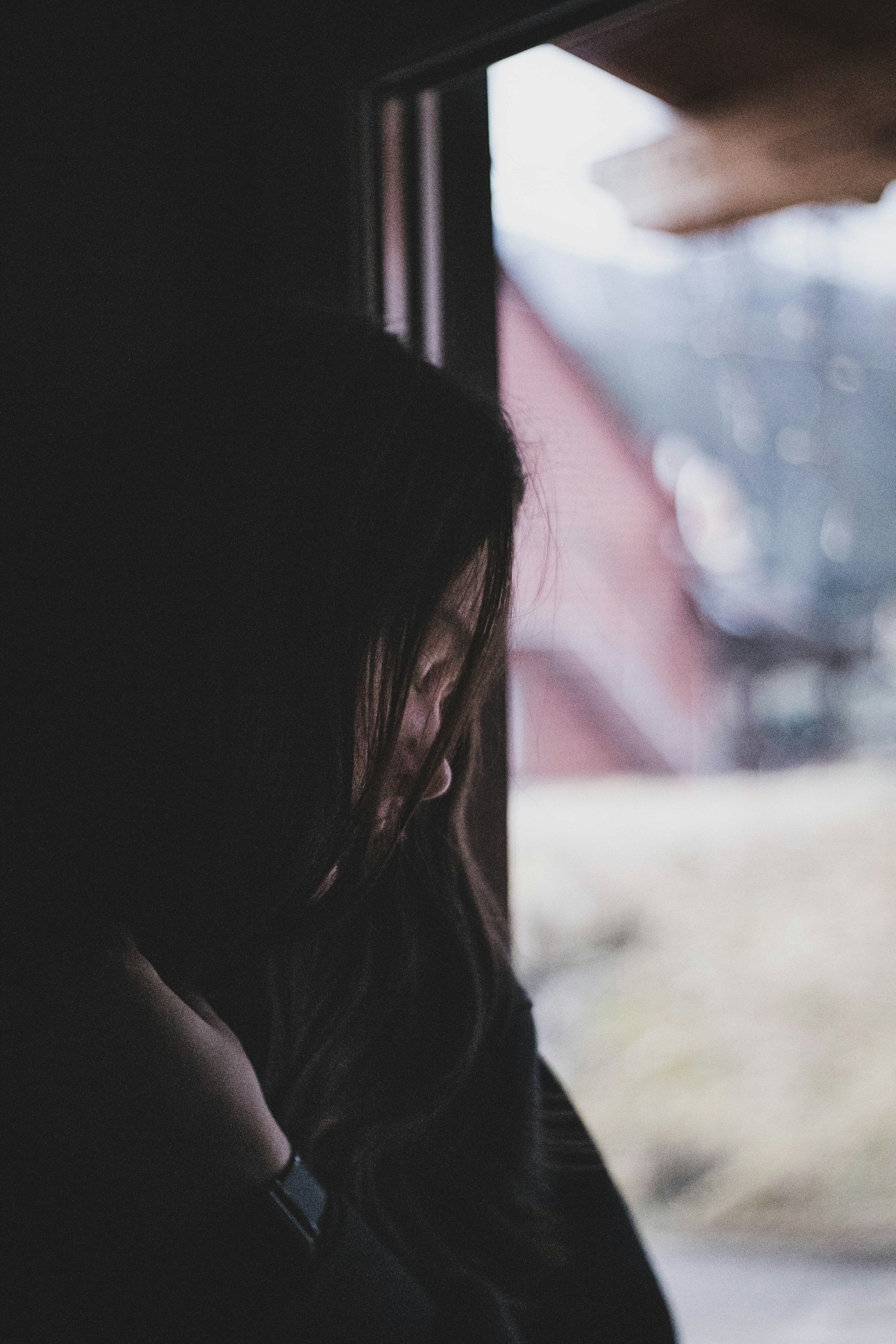 Person sitting near a window in low light, reflecting internal awareness and body-based trauma healing.