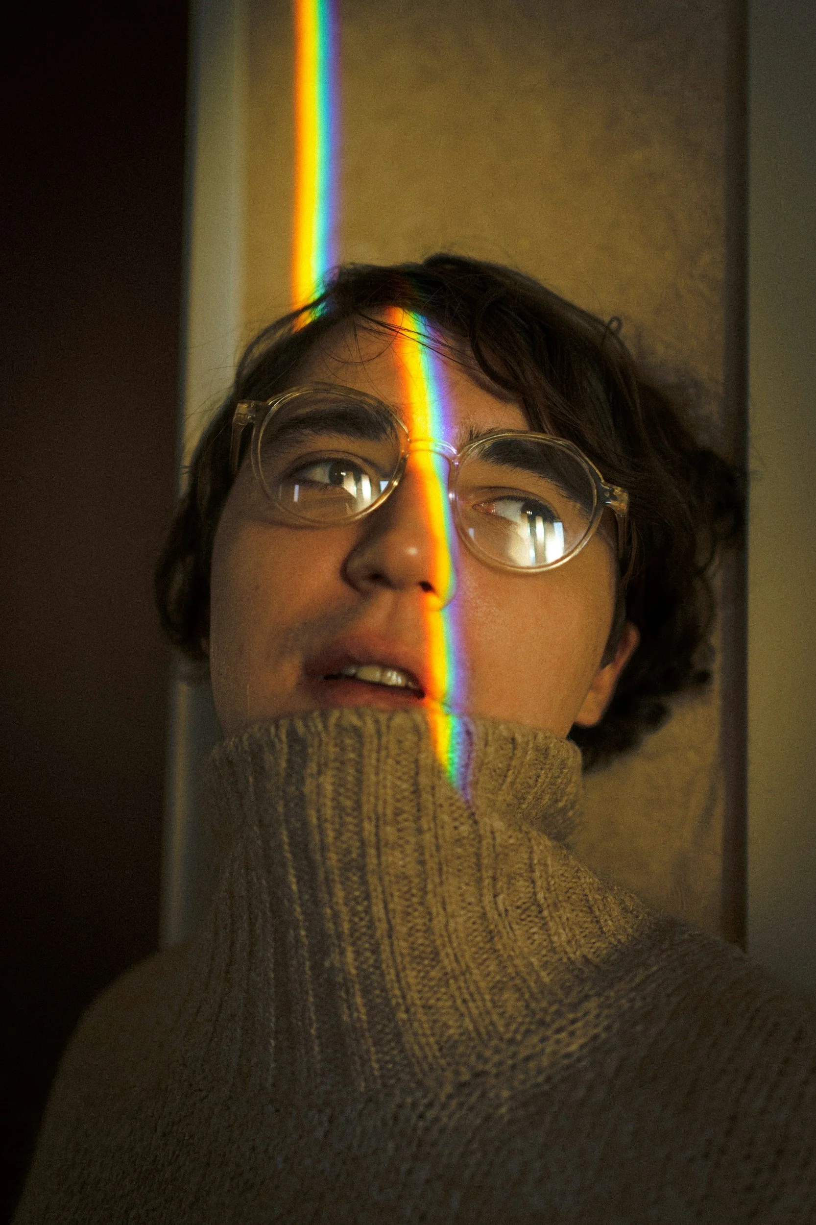 Person with a rainbow light across their face reflecting on identity, self-acceptance, and LGBTQIA+ mental health support in Philadelphia.