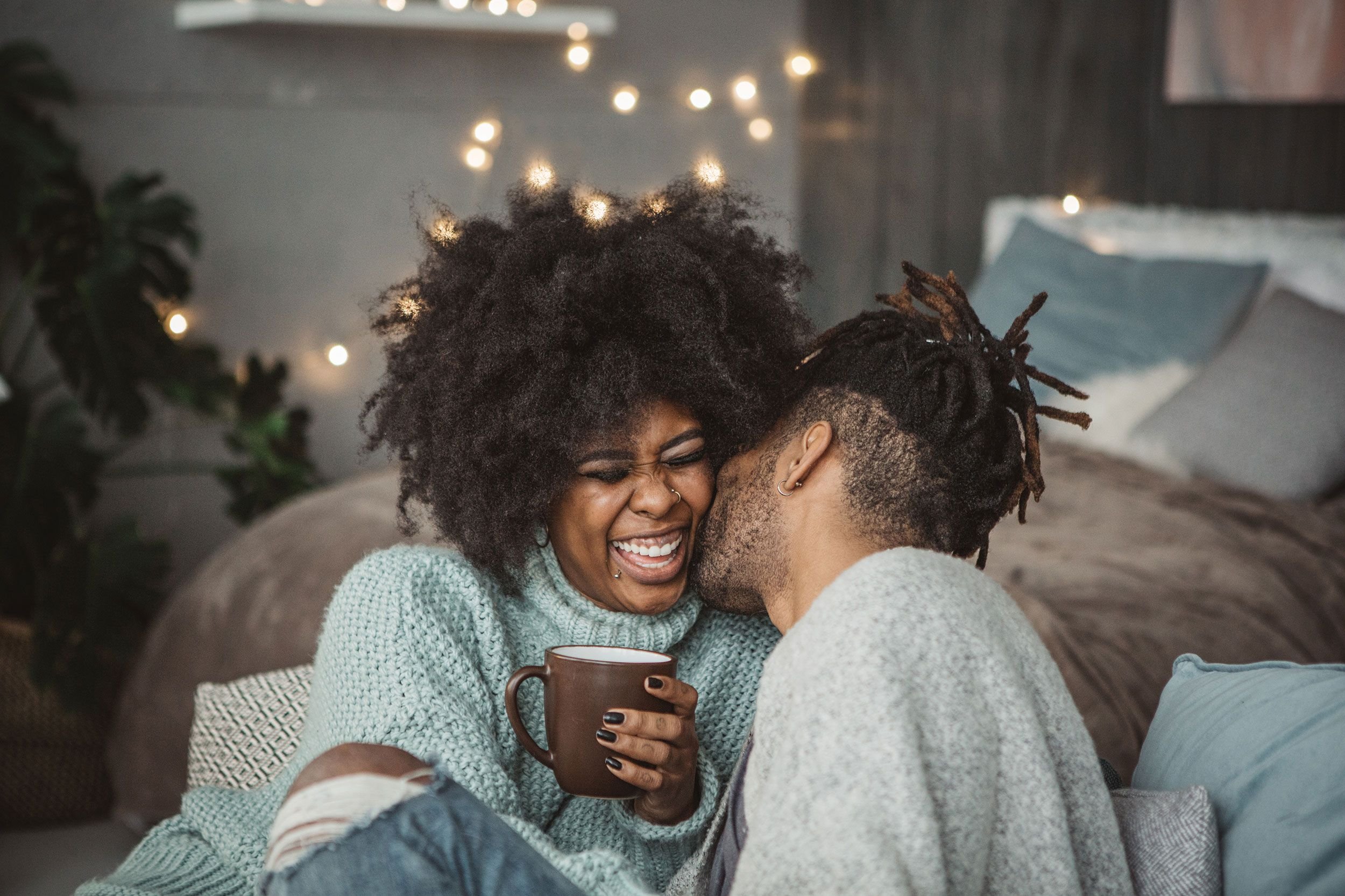 A couple relaxing together at home, laughing and reconnecting during the holidays after relationship stress — symbolizing emotional repair and couples therapy in Philadelphia and Bryn Mawr.