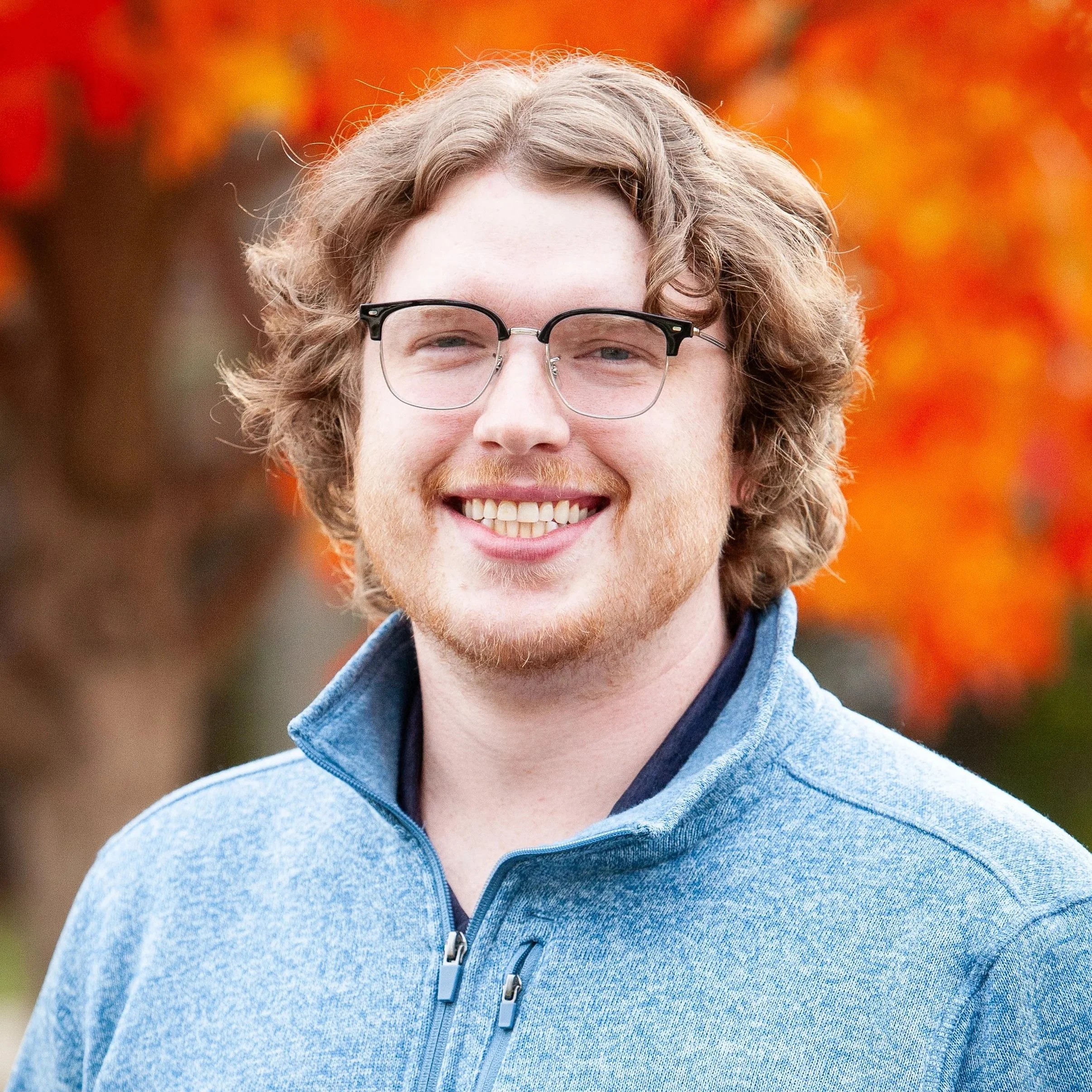 A man smiles outside