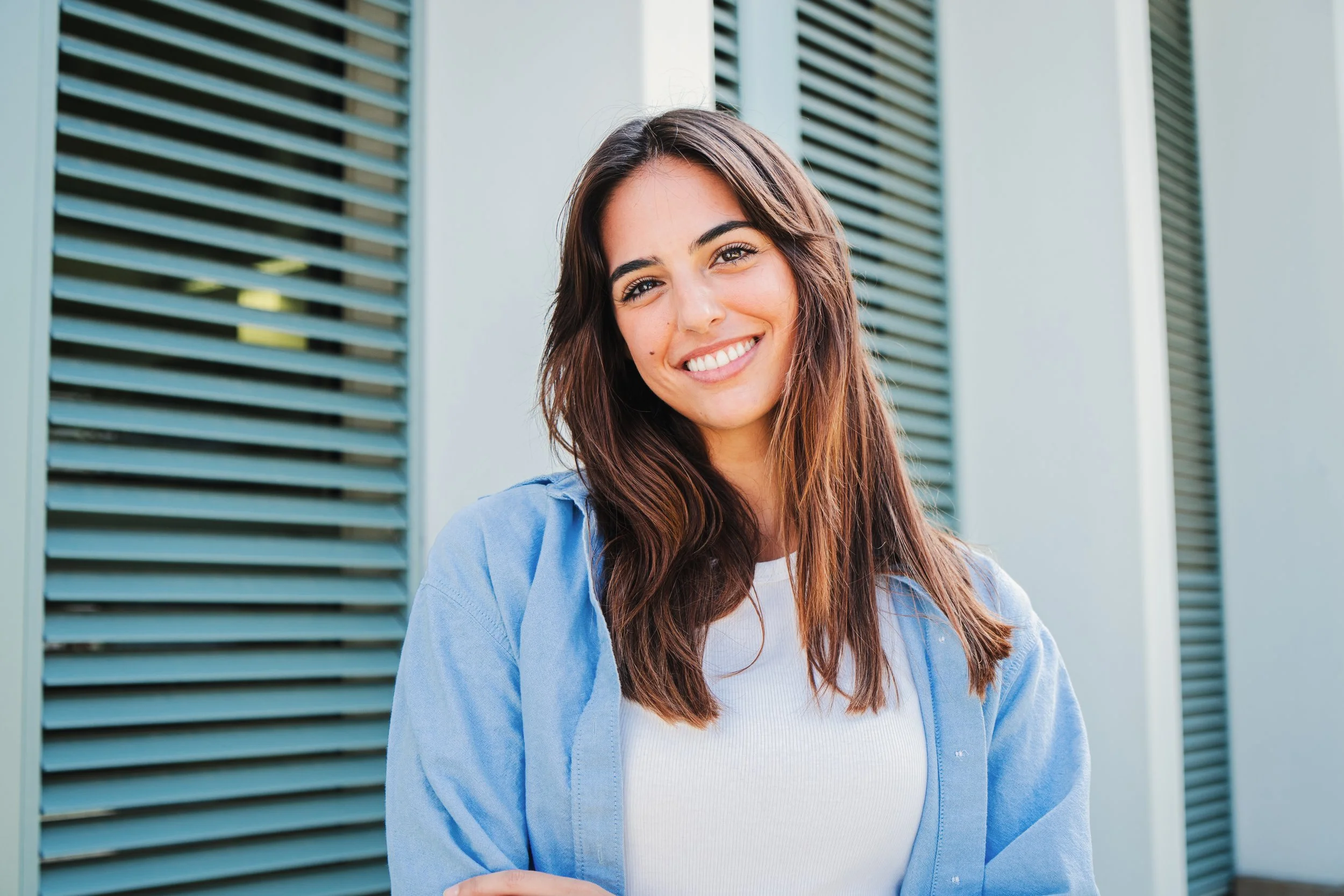 Mujer sonriendo en el exterior de un edificio