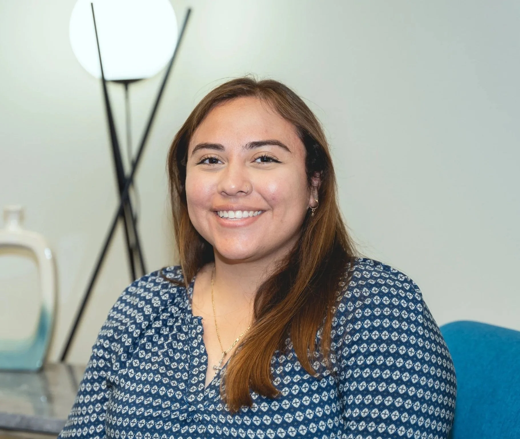 A woman smiles in an office.