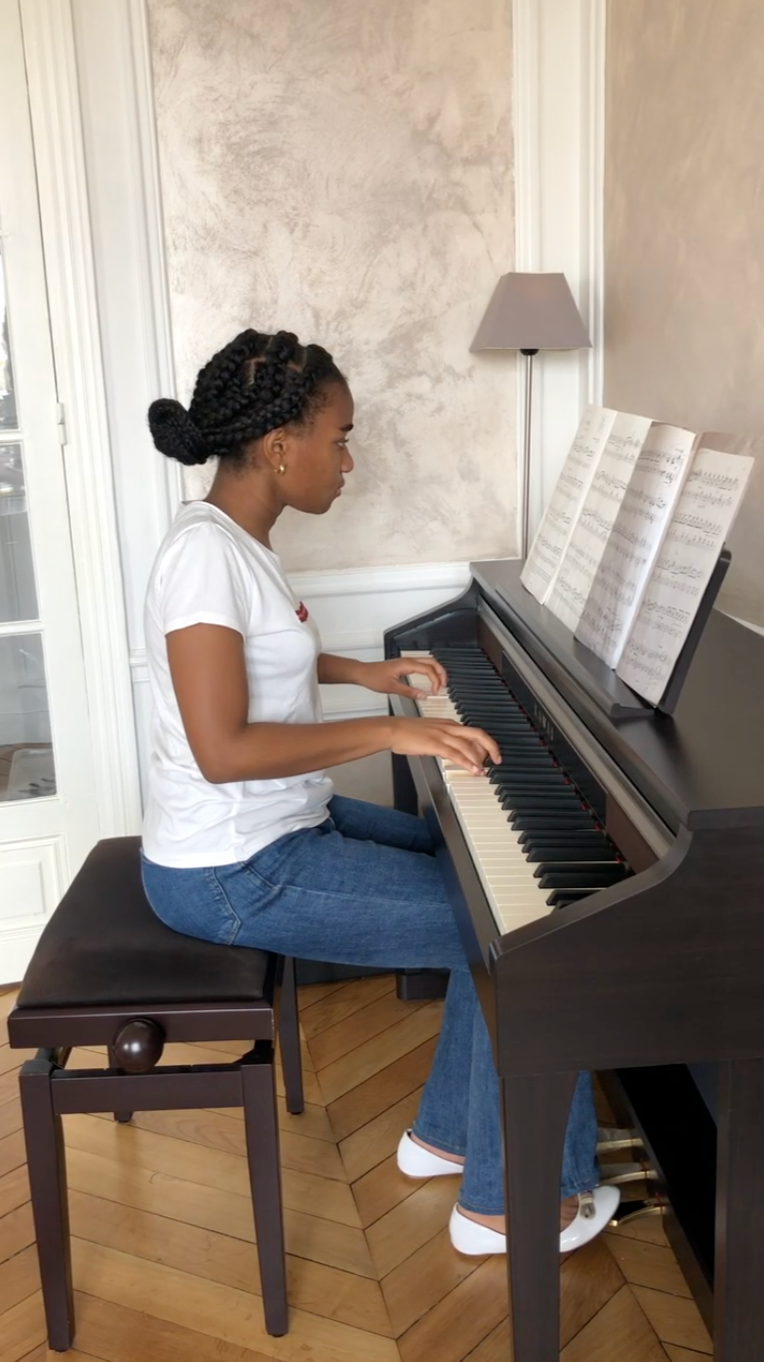 Teenager playing piano during online lesson at home