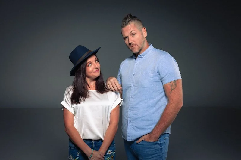Bryan Drake and his wife Karla posing together against a dark gray studio background.