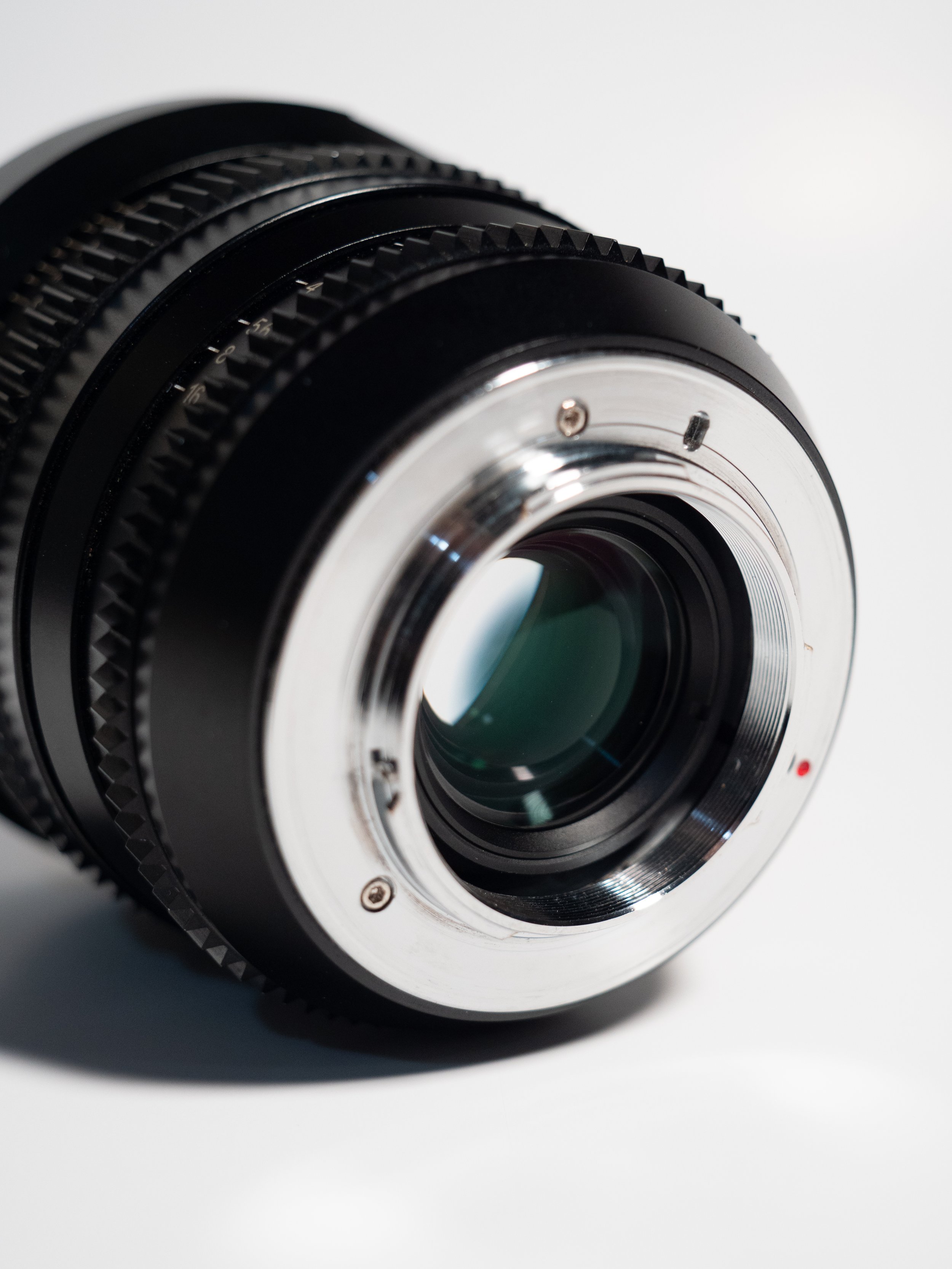 Close-up view of a camera lens focusing on the lens mount with metal edges and grooved rings.